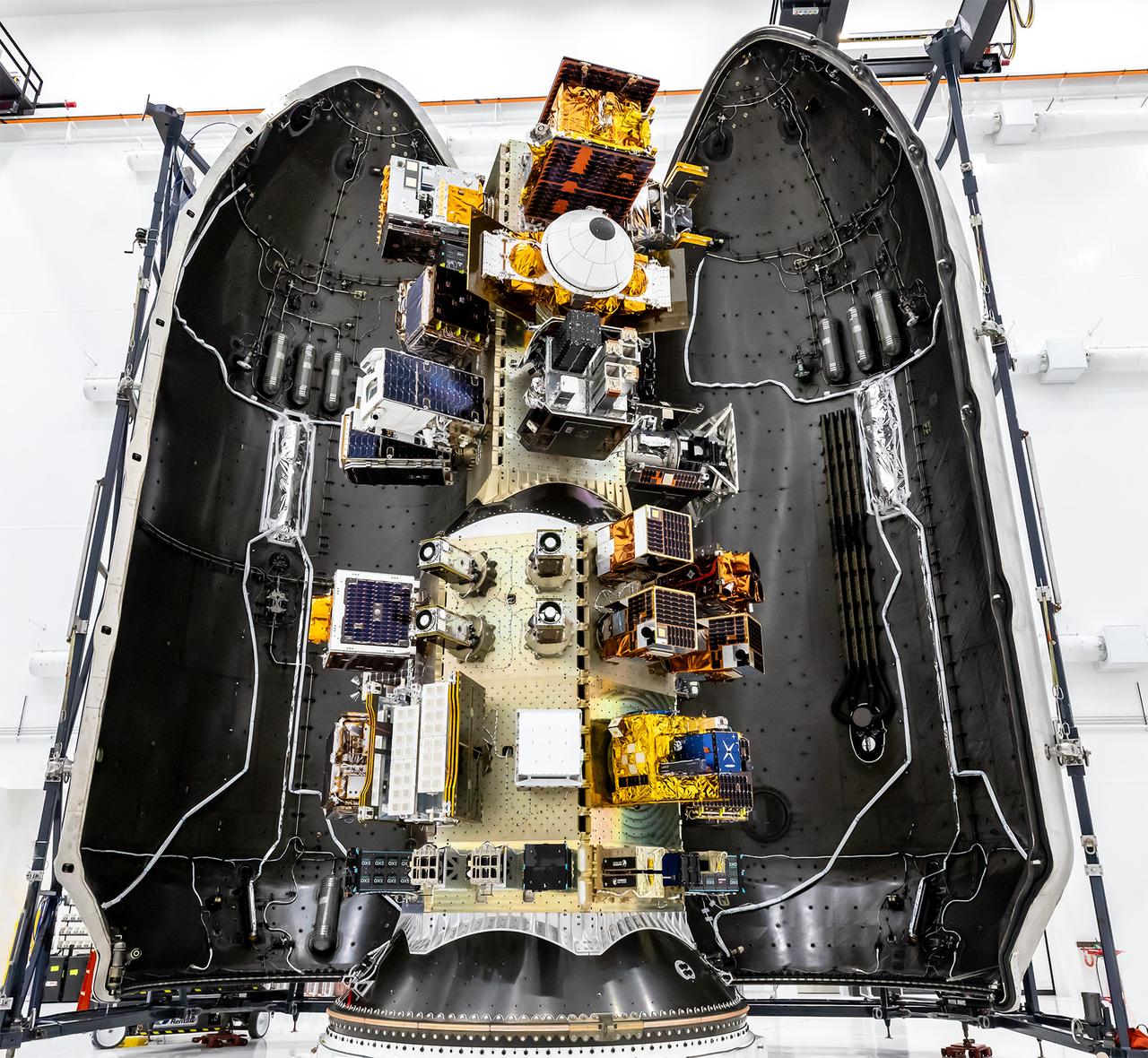 Three NASA-supported small spacecraft, shown along with many commercial payloads, before being encapsulated in a SpaceX Falcon 9. The rocket launched the payloads into low-Earth orbit at 11:32 a.m. PDT Thursday, Oct. 1, 2026, as part of the company’s Transporter-18 mission from Space Launch Complex 4 East at Vandenberg Space Force Base in California. The ASCENT Propulsion Dual Mode CubeSat, the Supernova Remnants and Proxies for ReIonization Testbed Experiment (SPRITE) CubeSat, and the Small Spacecraft Propulsion and Inspection Capability (SSPICY) mission will demonstrate new propulsion technologies, study how galactic dust and high-energy radiation move through galaxies, and advance capabilities for inspecting inactive satellites.