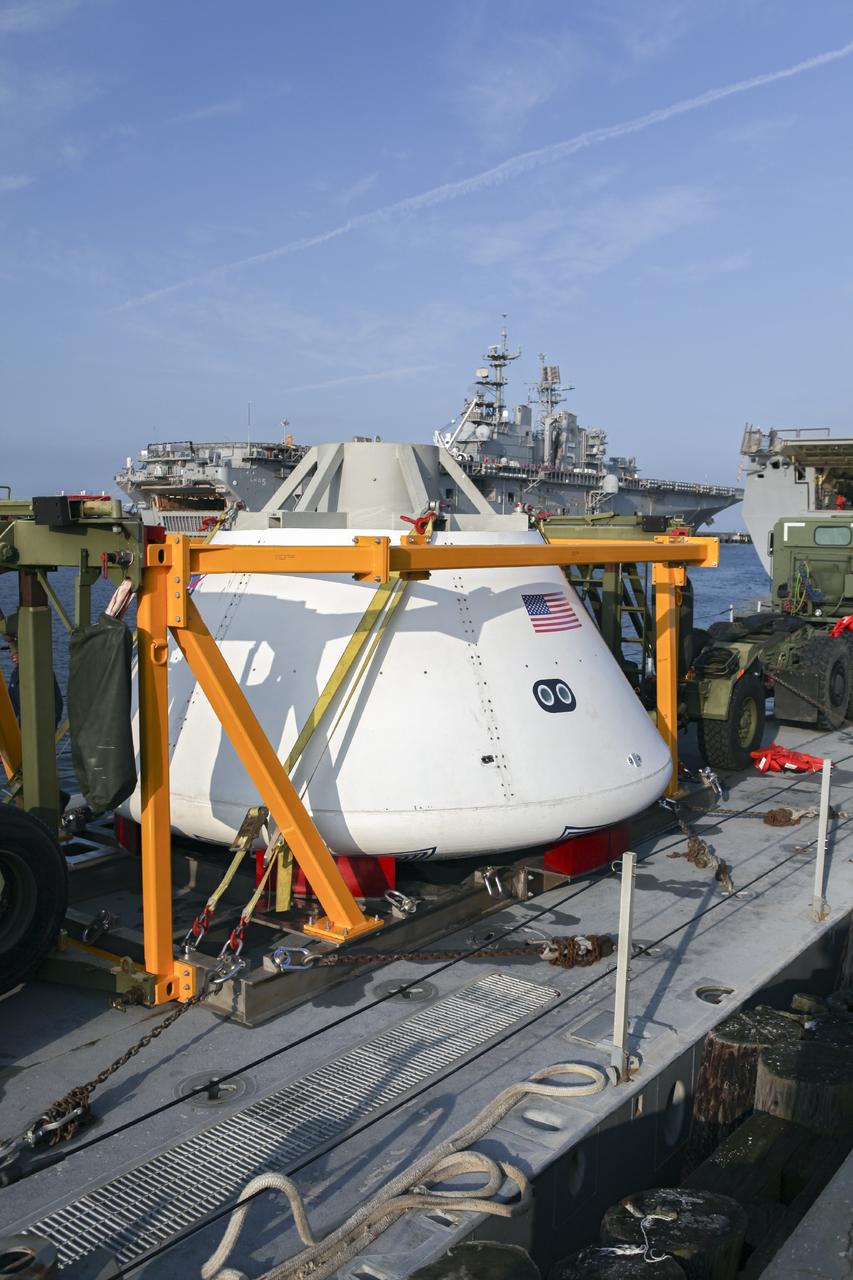 HAMPTON, Va. – At the Naval Station Norfolk near NASA’s Langley Research Center in Virginia, the Orion boilerplate test article and support equipment for a stationary recovery test are secured on a floating dock system for transfer to a U.S. Navy ship. NASA and the U.S. Navy are conducting tests to prepare for recovery of the Orion crew module and forward bay cover on its return from a deep space mission. The stationary recovery test will allow the teams to demonstrate and evaluate the recovery processes, procedures, hardware and personnel in a controlled environment before conducting a second recovery test next year in open waters. Orion is the exploration spacecraft designed to carry astronauts to destinations not yet explored by humans, including an asteroid and Mars. It will have emergency abort capability, sustain the crew during space travel and provide safe re-entry from deep space return velocities. The first unpiloted test flight of the Orion is scheduled to launch in 2014 atop a Delta IV rocket and in 2017 on a Space Launch System rocket. For more information, visit http://www.nasa.gov/orion. Photo credit: NASA/Dimitri Gerondidakis