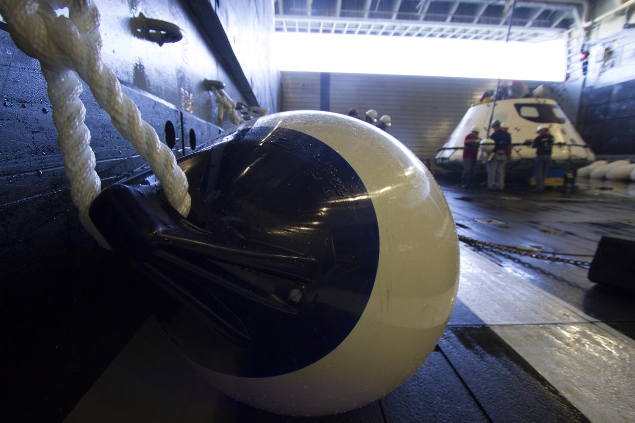 Underway Recovery Test team members help secure the Orion boilerplate test vehicle in the well deck of the USS Anchorage during the first day of Underway Recovery Test 3 in the Pacific Ocean. NASA, Lockheed Martin and U.S. Navy personnel are conducting the recovery test to prepare for recovery of the Orion crew module on its return from a deep space mission. The test allows the teams to demonstrate and evaluate the recovery processes, procedures, hardware and personnel in open waters. The Ground Systems Development and Operations Program is conducting the underway recovery tests. Orion is the exploration spacecraft designed to carry astronauts to destinations not yet explored by humans, including an asteroid and Mars. It will have emergency abort capability, sustain the crew during space travel and provide safe re-entry from deep space return velocities. The first unpiloted test flight of Orion is scheduled to launch in 2014 atop a United Launch Alliance Delta IV Heavy rocket and in 2018 on NASA’s Space Launch System rocket. 