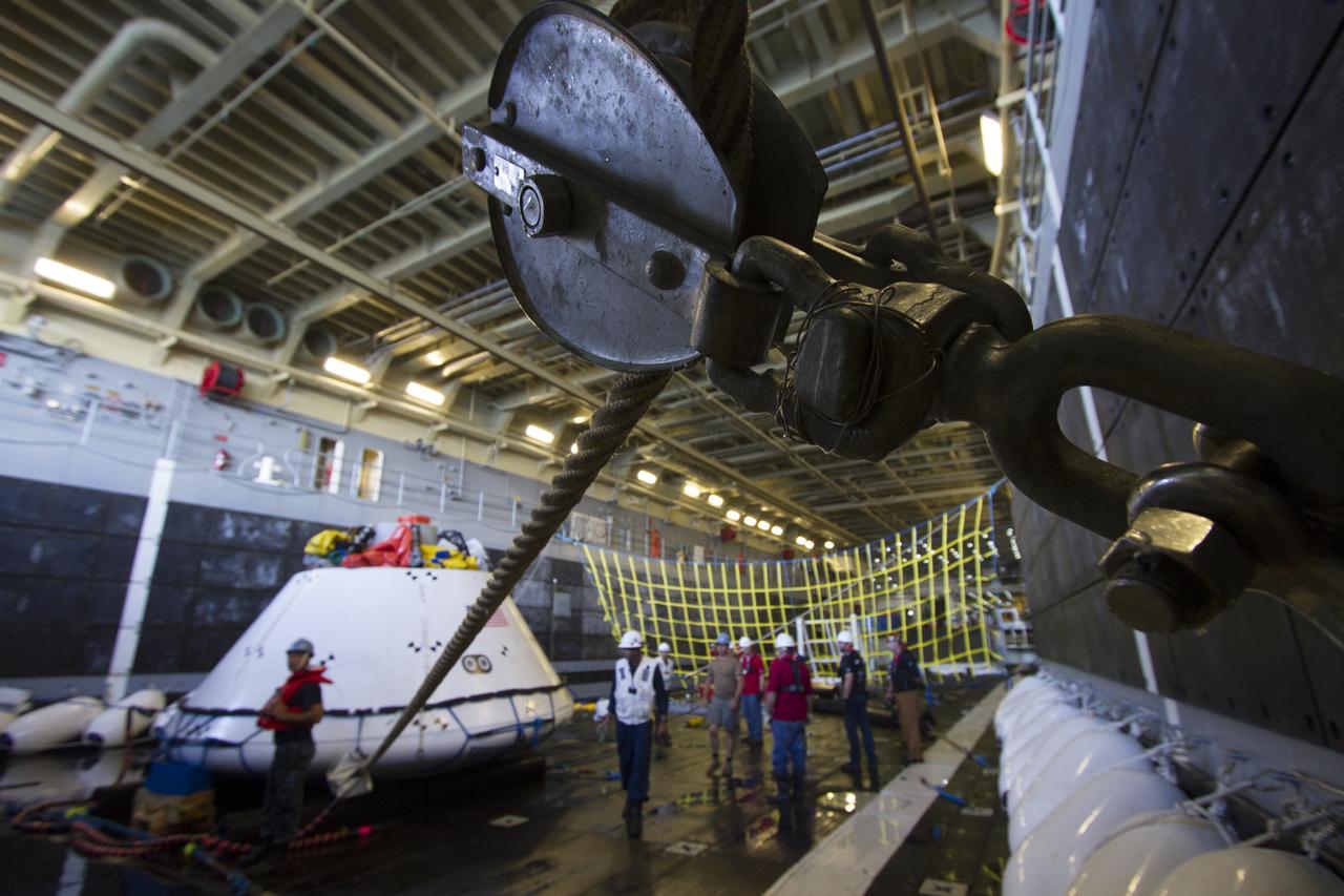 Underway Recovery Test team members help secure the Orion boilerplate test vehicle in the well deck of the USS Anchorage during the first day of Underway Recovery Test 3 in the Pacific Ocean. NASA, Lockheed Martin and U.S. Navy personnel are conducting the recovery test to prepare for recovery of the Orion crew module on its return from a deep space mission. The test allows the teams to demonstrate and evaluate the recovery processes, procedures, hardware and personnel in open waters. The Ground Systems Development and Operations Program is conducting the underway recovery tests. Orion is the exploration spacecraft designed to carry astronauts to destinations not yet explored by humans, including an asteroid and Mars. It will have emergency abort capability, sustain the crew during space travel and provide safe re-entry from deep space return velocities. The first unpiloted test flight of Orion is scheduled to launch in 2014 atop a United Launch Alliance Delta IV Heavy rocket and in 2018 on NASA’s Space Launch System rocket. 