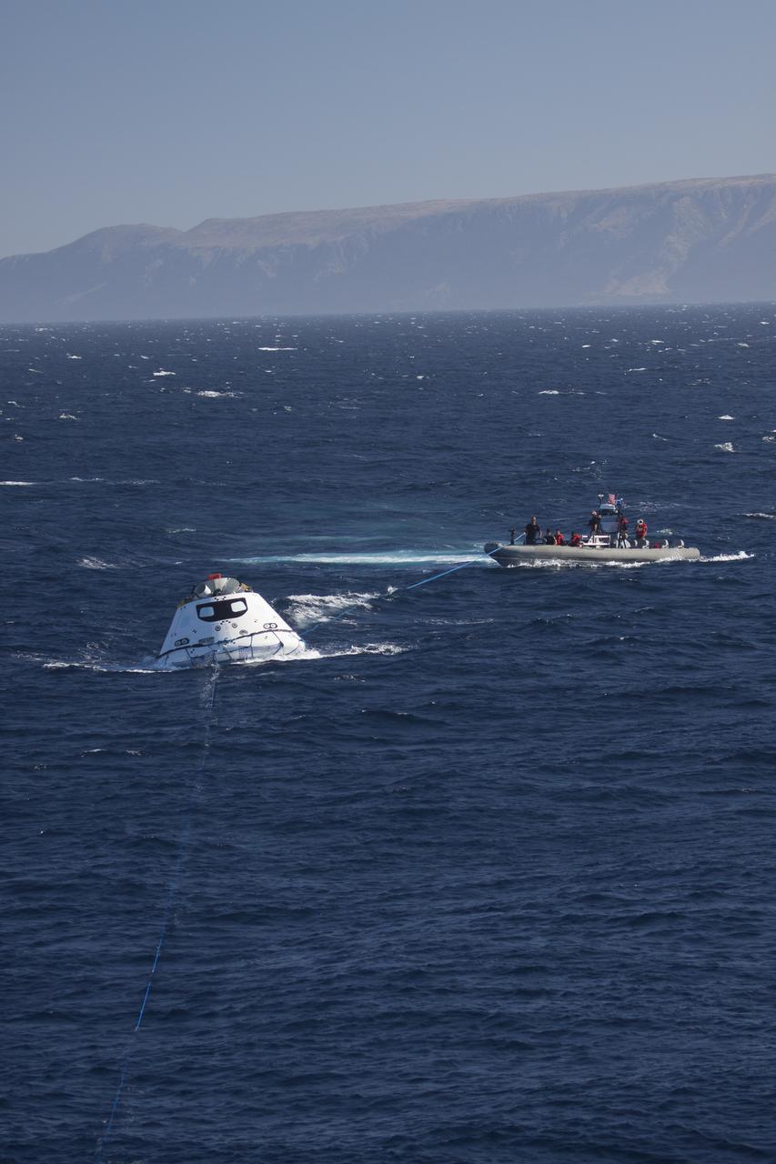 The Orion boilerplate test vehicle floats in the Pacific Ocean near the USS Anchorage during Underway Recovery Test 3. Tether lines have been attached to the test vehicle. Nearby, recovery team members in a rigid hull inflatable boat are practicing recovery procedures. NASA, Lockheed Martin and U.S. Navy personnel are conducting the recovery test to prepare for recovery of the Orion crew module on its return from a deep space mission. The test allows the teams to demonstrate and evaluate the recovery processes, procedures, hardware and personnel in open waters. The Ground Systems Development and Operations Program is conducting the underway recovery tests. Orion is the exploration spacecraft designed to carry astronauts to destinations not yet explored by humans, including an asteroid and Mars. It will have emergency abort capability, sustain the crew during space travel and provide safe re-entry from deep space return velocities. The first unpiloted test flight of Orion is scheduled to launch in 2014 atop a United Launch Alliance Delta IV Heavy rocket and in 2018 on NASA’s Space Launch System rocket. 