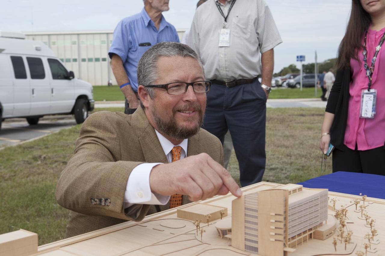 Groundbreaking for the new Central Campus took place in the Industrial Area at NASA's Kennedy Space Center in Florida. Steve Belflower, vice president of HuntonBrady Architects of Orlando, points to a scale model of the Central Campus building on display during the groundbreaking ceremony. Kennedy is transforming into a multi-user, 21st century spaceport supporting both commercial and government users and operations. Central Campus Phase I includes construction of a new Headquarters Building as one of the major components of the strategy. The new Headquarters Building will be a seven-story, 200,000-square-foot facility that will house about 500 NASA civil service and contractor employees.