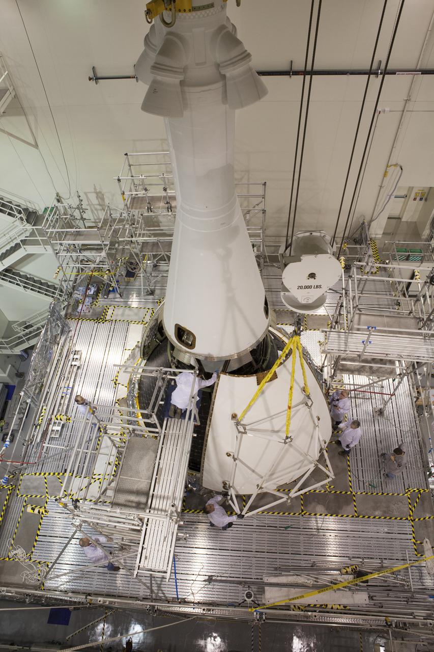 Technicians on work platforms continue the installation of four Ogive panels on Orion's Launch Abort System inside the Launch Abort System Facility at NASA’s Kennedy Space Center in Florida. The panels will smooth the airflow over the conical spacecraft to limit sound and vibration, which will make for a much smoother ride for the astronauts who will ride inside Orion in the future. The work marked the final major assembly steps for the spacecraft before it is transported to Space Launch Complex 37 at Cape Canaveral Air Force Station in November. Orion is the exploration spacecraft designed to carry astronauts to destinations not yet explored by humans, including an asteroid and Mars. It will have emergency abort capability, sustain the crew during space travel and provide safe re-entry from deep space return velocities. The first unpiloted flight test of Orion is scheduled to launch in December 2014 atop a United Launch Alliance Delta IV Heavy rocket, and in 2018 on NASA’s Space Launch System rocket.