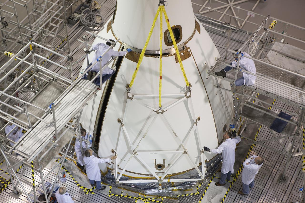 Inside the Launch Abort System Facility at NASA’s Kennedy Space Center in Florida, technicians attach the third of four Ogive panels on Orion's Launch Abort System. The panels will smooth the airflow over the conical spacecraft to limit sound and vibration, which will make for a much smoother ride for the astronauts who will ride inside Orion in the future. The work marked the final major assembly steps for the spacecraft before it is transported to Space Launch Complex 37 at Cape Canaveral Air Force Station in November. Orion is the exploration spacecraft designed to carry astronauts to destinations not yet explored by humans, including an asteroid and Mars. It will have emergency abort capability, sustain the crew during space travel and provide safe re-entry from deep space return velocities. The first unpiloted flight test of Orion is scheduled to launch in December 2014 atop a United Launch Alliance Delta IV Heavy rocket, and in 2018 on NASA’s Space Launch System rocket.