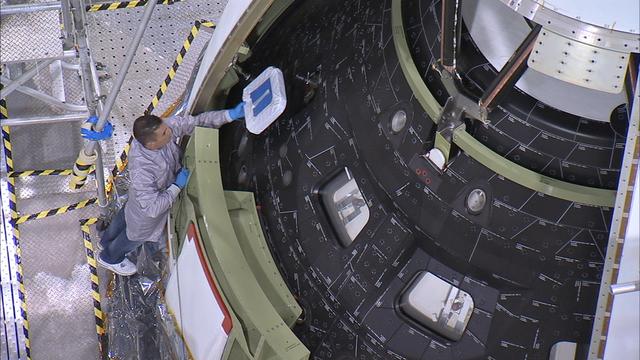 Inside the Launch Abort System Facility at NASA's Kennedy Space Center in Florida, a technician on a work platform carefully removes the window covers on Orion before the fourth and final Ogive panel is installed around the spacecraft and Launch Abort System. The Ogive panels will smooth the airflow over the conical spacecraft to limit sound and vibration, which will make for a much smoother ride for the astronauts who will ride inside Orion in the future. The work marked the final major assembly steps for the spacecraft before it is transported to Space Launch Complex 37 at Cape Canaveral Air Force Station in November. Orion is the exploration spacecraft designed to carry astronauts to destinations not yet explored by humans, including an asteroid and Mars. It will have emergency abort capability, sustain the crew during space travel and provide safe re-entry from deep space return velocities. The first unpiloted flight test of Orion is scheduled to launch in December 2014 atop a United Launch Alliance Delta IV Heavy rocket, and in 2018 on NASA’s Space Launch System rocket.