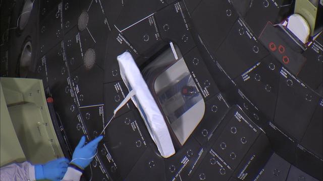 Inside the Launch Abort System Facility at NASA's Kennedy Space Center in Florida, a technician carefully removes the window covers on Orion before the fourth and final Ogive panel is installed around the spacecraft and Launch Abort System. The Ogive panels will smooth the airflow over the conical spacecraft to limit sound and vibration, which will make for a much smoother ride for the astronauts who will ride inside Orion in the future. The work marked the final major assembly steps for the spacecraft before it is transported to Space Launch Complex 37 at Cape Canaveral Air Force Station in November. Orion is the exploration spacecraft designed to carry astronauts to destinations not yet explored by humans, including an asteroid and Mars. It will have emergency abort capability, sustain the crew during space travel and provide safe re-entry from deep space return velocities. The first unpiloted flight test of Orion is scheduled to launch in December 2014 atop a United Launch Alliance Delta IV Heavy rocket, and in 2018 on NASA’s Space Launch System rocket.