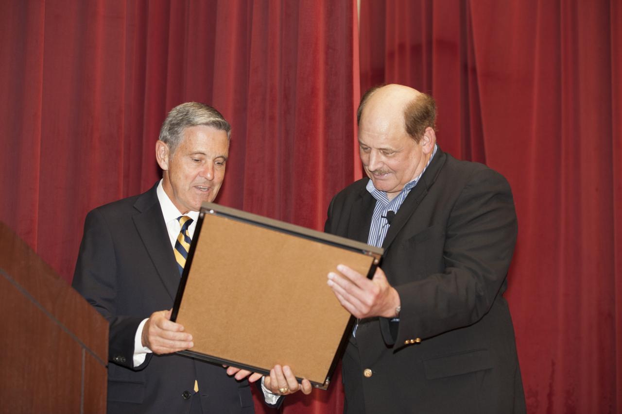 NASA Kennedy Space Center Director Bob Cabana, left, presents a special plaque to Michael Kersjes, author and former special education teacher and football coach from Michigan, after his presentation to workers during the Disability Awareness and Action Working Group, or DAAWG, event. The theme of Kersjes' presentation was "Power of the Human Spirit." Kersjes is the author of the book, "A Smile as Big as the Moon," which told the true story of how he worked to get special education students into Space Camp, a competitive education program at the U.S. Space and Rocket Center in Huntsville, Alabama. His book was made into a movie in 2012.