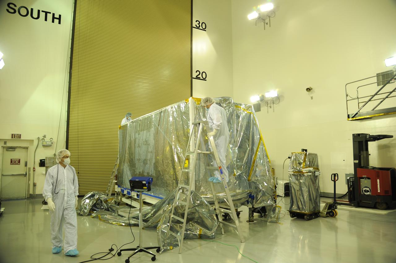 Preparations are underway to remove the protective covering from NASA's Soil Moisture Active Passive, or SMAP, spacecraft in the Astrotech payload processing facility on Vandenberg Air Force Base in California during a post-shipment inspection. The covering protects the spacecraft from static-charge buildup and contamination. SMAP will launch on a Delta II 7320 configuration vehicle featuring a United Launch Alliance first stage booster powered by an Aerojet Rocketdyne RS-27A main engine and three Alliant Techsystems, or ATK, strap-on solid rocket motors. Once on station in Earth orbit, SMAP will provide global measurements of soil moisture and its freeze/thaw state. These measurements will be used to enhance understanding of processes that link the water, energy and carbon cycles, and to extend the capabilities of weather and climate prediction models. SMAP data also will be used to quantify net carbon flux in boreal landscapes and to develop improved flood prediction and drought monitoring capabilities. Launch from Space Launch Complex 2 is targeted for Jan. 29, 2015.