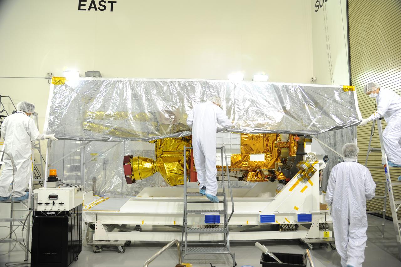 Workers replace the protective covering around NASA's Soil Moisture Active Passive, or SMAP, spacecraft following the spacecraft's post-shipment inspection in the Astrotech payload processing facility on Vandenberg Air Force Base in California. The covering protected the spacecraft from static-charge buildup and contamination while it was in transit from NASA's Jet Propulsion Laboratory in Pasadena, California. SMAP will launch on a Delta II 7320 configuration vehicle featuring a United Launch Alliance first stage booster powered by an Aerojet Rocketdyne RS-27A main engine and three Alliant Techsystems, or ATK, strap-on solid rocket motors. Once on station in Earth orbit, SMAP will provide global measurements of soil moisture and its freeze/thaw state. These measurements will be used to enhance understanding of processes that link the water, energy and carbon cycles, and to extend the capabilities of weather and climate prediction models. SMAP data also will be used to quantify net carbon flux in boreal landscapes and to develop improved flood prediction and drought monitoring capabilities. Launch from Space Launch Complex 2 is targeted for Jan. 29, 2015.