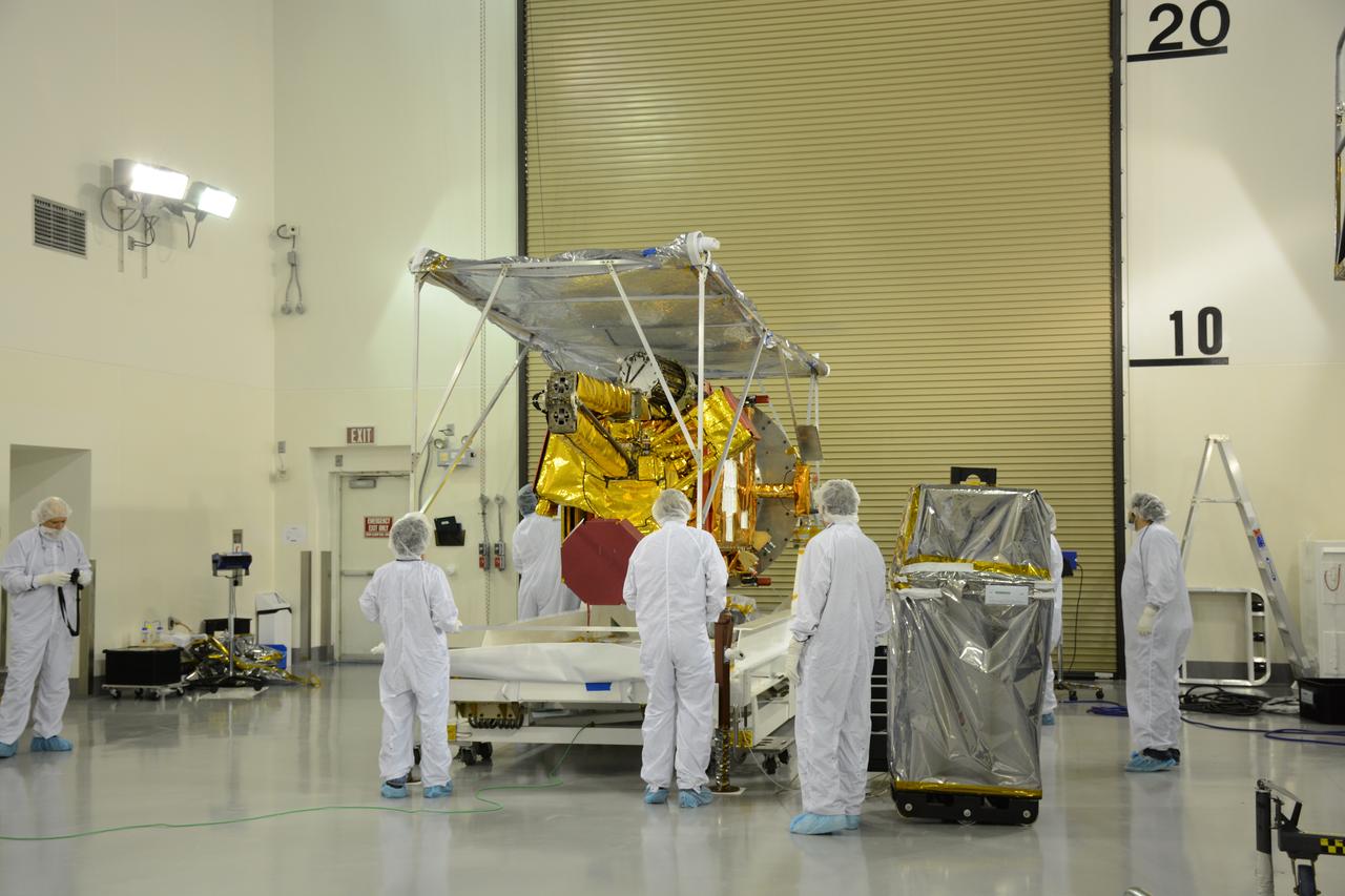 Inside the Astrotech payload processing facility on Vandenberg Air Force Base in California, engineers and technicians remove a protective covering from NASA's Soil Moisture Active Passive, or SMAP, spacecraft. SMAP will launch on a Delta II 7320 configuration vehicle featuring a United Launch Alliance first stage booster powered by an Aerojet Rocketdyne RS-27A main engine and three Alliant Techsystems, or ATK, strap-on solid rocket motors. Once on station in Earth orbit, SMAP will provide global measurements of soil moisture and its freeze/thaw state. These measurements will be used to enhance understanding of processes that link the water, energy and carbon cycles, and to extend the capabilities of weather and climate prediction models. SMAP data also will be used to quantify net carbon flux in boreal landscapes and to develop improved flood prediction and drought monitoring capabilities. Launch from Space Launch Complex 2 is targeted for Jan. 29, 2015.