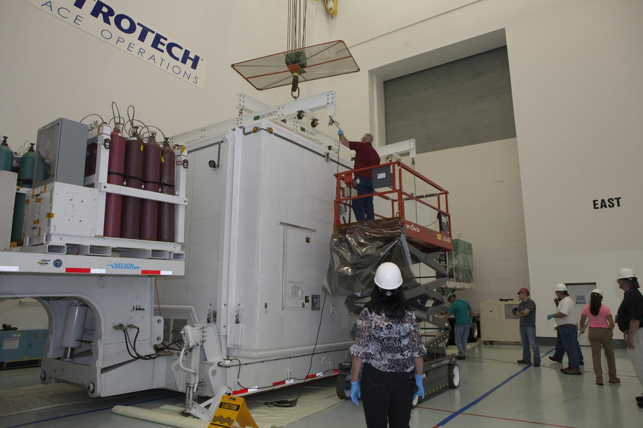 Workers attach a crane to the protective shipping container to prepare to uncover the lower stack, mini-stack number 1, two of the observatories for NASA's Magnetospheric Multiscale Observatory, or MMS. They were delivered to the Building 2 south encapsulation bay at the Astrotech payload processing facility in Titusville, Florida, near Kennedy Space Center. The MMS upper stack, mini-stack number 2, is scheduled to arrive in about two weeks. MMS is a Solar Terrestrial Probes mission comprising four identically instrumented spacecraft that will use Earth’s magnetosphere as a laboratory to study the microphysics of three fundamental plasma processes: magnetic reconnection, energetic particle acceleration and turbulence. Launch aboard a United Launch Alliance Atlas V rocket from Space Launch Complex 41 on Cape Canaveral Air Force Station is targeted for March 12, 2015.