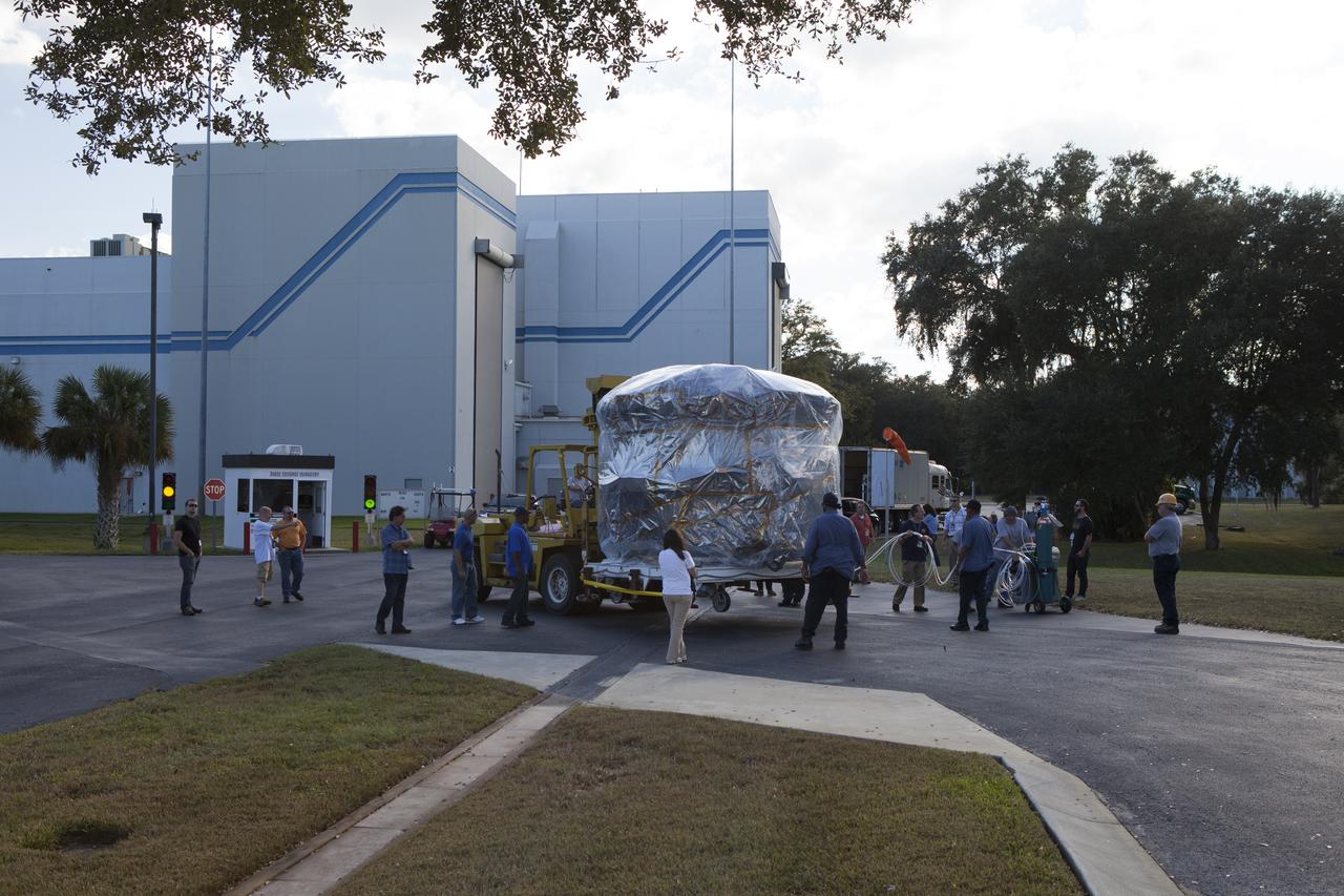 Workers surround two of the observatories, the lower stack, mini-stack number 1, for NASA's Magnetospheric Multiscale Observatory, or MMS, on their trip from the Building 2 south encapsulation bay to the Building 1 high bay at the Astrotech payload processing facility in Titusville, Florida, near Kennedy Space Center. The MMS upper stack, mini-stack number 2, is scheduled to arrive in about two weeks. MMS is a Solar Terrestrial Probes mission comprising four identically instrumented spacecraft that will use Earth’s magnetosphere as a laboratory to study the microphysics of three fundamental plasma processes: magnetic reconnection, energetic particle acceleration and turbulence. Launch aboard a United Launch Alliance Atlas V rocket from Space Launch Complex 41 on Cape Canaveral Air Force Station is targeted for March 12, 2015.