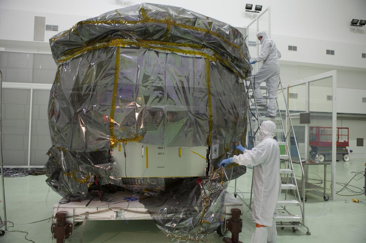 Technicians begin to remove the protective covering from the lower stack, mini-stack number 1, two of the observatories for NASA's Magnetospheric Multiscale Observatory, or MMS, in Building 1 D high bay at the Astrotech payload processing facility in Titusville, Florida, near Kennedy Space Center. The MMS upper stack, mini-stack number 2, is scheduled to arrive in about two weeks. MMS is a Solar Terrestrial Probes mission comprising four identically instrumented spacecraft that will use Earth’s magnetosphere as a laboratory to study the microphysics of three fundamental plasma processes: magnetic reconnection, energetic particle acceleration and turbulence. Launch aboard a United Launch Alliance Atlas V rocket from Space Launch Complex 41 on Cape Canaveral Air Force Station is targeted for March 12, 2015. 