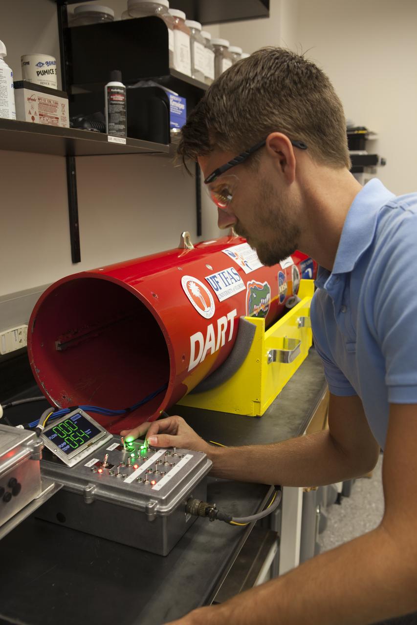 A researcher at NASA’s Kennedy Space Center in Florida checks a reading on the Dust Atmospheric Recovery Technology, or DART, spacecraft inside a laboratory at the Space Life Sciences Lab. DART will characterize the dust loading and microbial diversity in the atmosphere over Florida during summer months with a special emphasis on their interactions during an African dust storm. DART will be used to collect atmospheric aerosols and suspended microbial cells over Florida and Kennedy. Results will help predict the risks of excessive microbial contamination adhering to spacecraft surfaces.