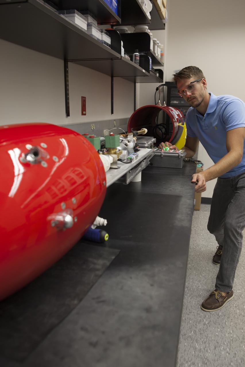 A researcher at NASA’s Kennedy Space Center in Florida checks a reading on the Dust Atmospheric Recovery Technology, or DART, spacecraft inside a laboratory at the Space Life Sciences Lab. DART will characterize the dust loading and microbial diversity in the atmosphere over Florida during summer months with a special emphasis on their interactions during an African dust storm. DART will be used to collect atmospheric aerosols and suspended microbial cells over Florida and Kennedy. Results will help predict the risks of excessive microbial contamination adhering to spacecraft surfaces. 