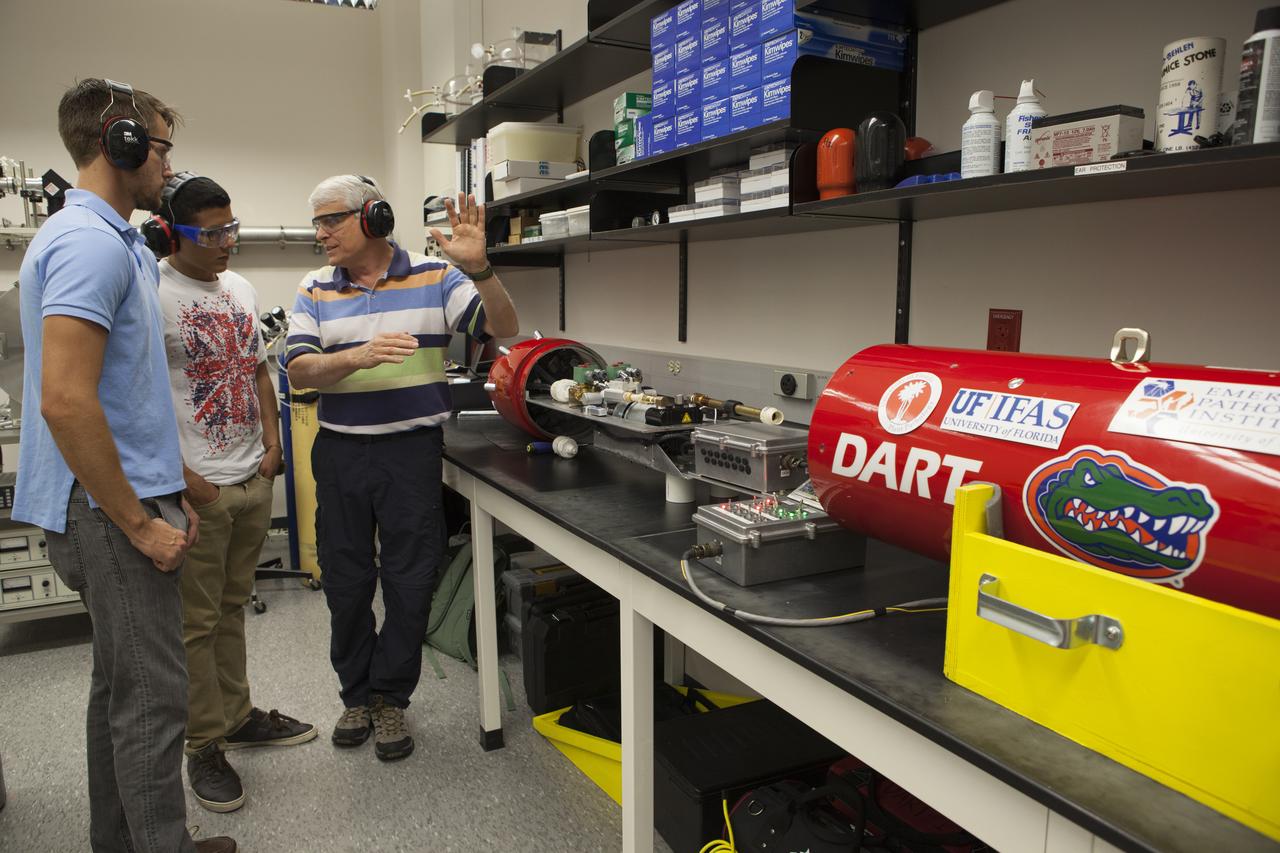 Researchers at NASA’s Kennedy Space Center in Florida check readings on the Dust Atmospheric Recovery Technology, or DART, spacecraft inside a laboratory at the Space Life Sciences Lab. DART will characterize the dust loading and microbial diversity in the atmosphere over Florida during summer months with a special emphasis on their interactions during an African dust storm. DART will be used to collect atmospheric aerosols and suspended microbial cells over Florida and Kennedy. Results will help predict the risks of excessive microbial contamination adhering to spacecraft surfaces.