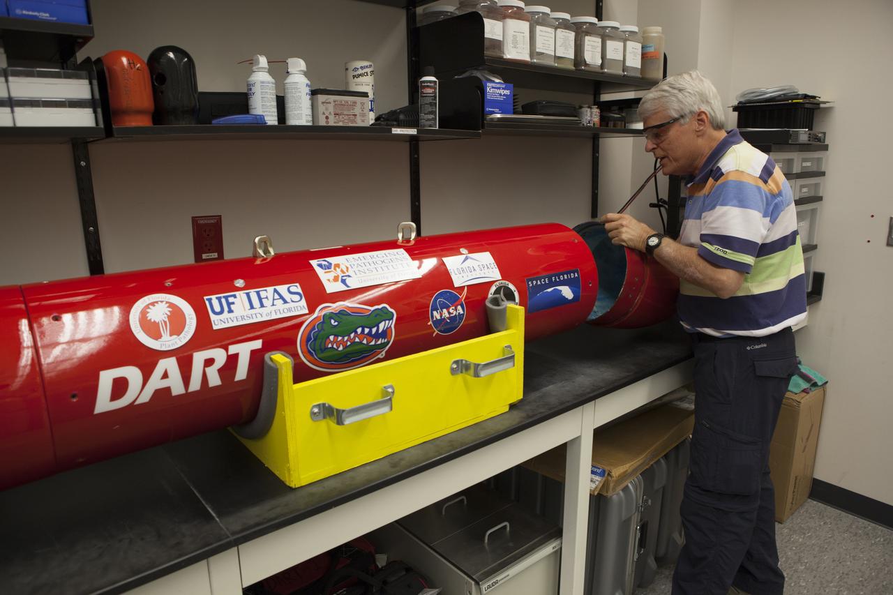 A researcher from the University of Florida in Gainesville, checks the Dust Atmospheric Recovery Technology, or DART, spacecraft in a laboratory inside the Space Life Sciences Lab at NASA’s Kennedy Space Center in Florida. DART will characterize the dust loading and microbial diversity in the atmosphere over Florida during summer months with a special emphasis on their interactions during an African dust storm. DART will be used to collect atmospheric aerosols and suspended microbial cells over Florida and Kennedy. Results will help predict the risks of excessive microbial contamination adhering to spacecraft surfaces.