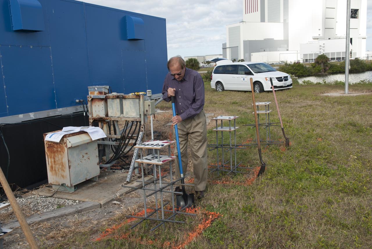At NASA's Kennedy Space Center in Florida, Public Affairs Officer George Diller digs in behind the current countdown clock during the groundbreaking ceremony for the new countdown clock. The old timepiece was designed by Kennedy engineers and built by Kennedy technicians in 1969. Not including the triangular concrete and aluminum base, the famous landmark is nearly 6 feet 70 inches high, 26 feet 315 inches wide and 3 feet deep. The new display will be similar in size, with the screen being nearly 26 feet wide by 7 feet high. 