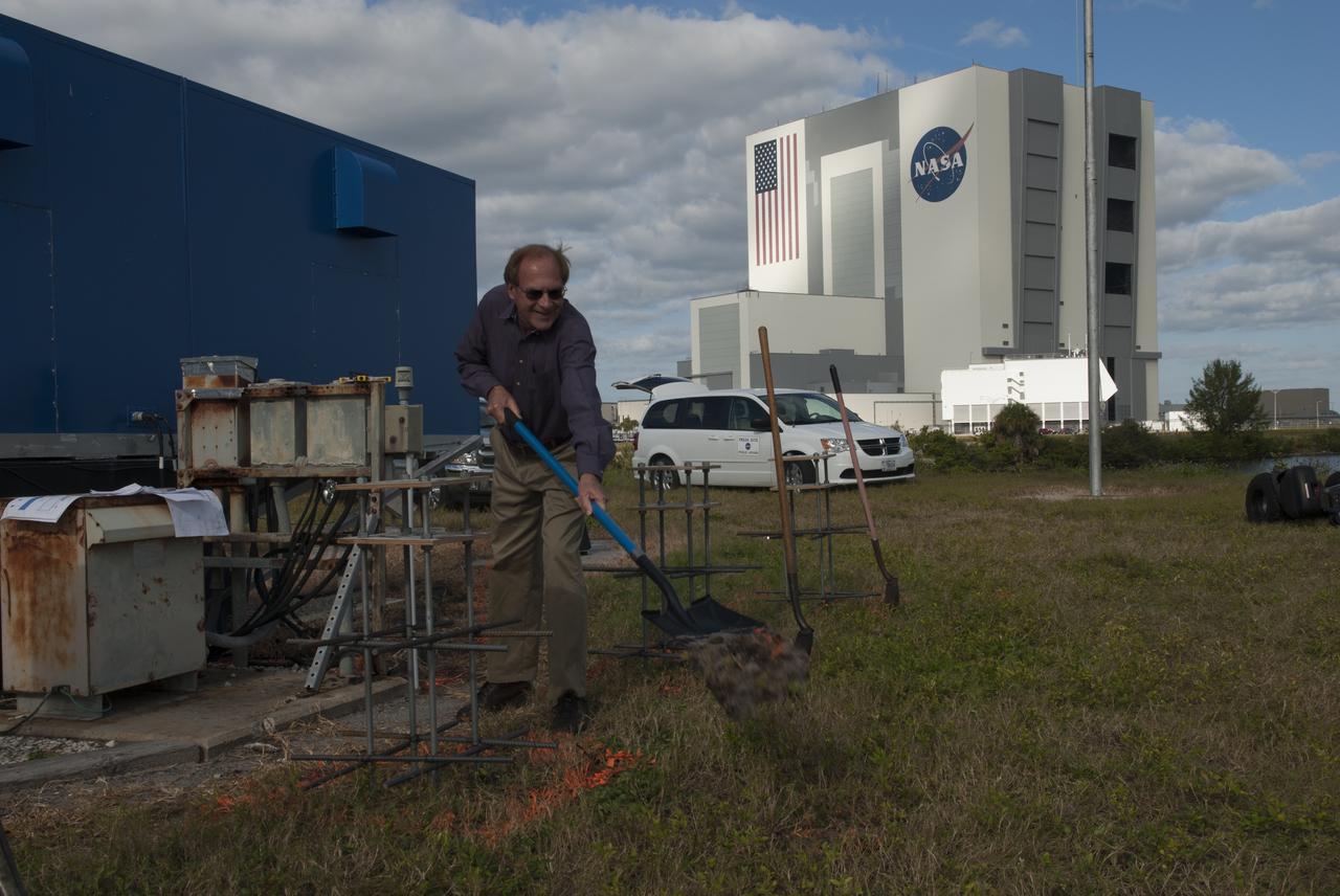At NASA's Kennedy Space Center in Florida, Public Affairs Officer George Diller shovels the first scoop of soil behind the current countdown clock during the groundbreaking ceremony for the new countdown clock. The old timepiece was designed by Kennedy engineers and built by Kennedy technicians in 1969. Not including the triangular concrete and aluminum base, the famous landmark is nearly 6 feet 70 inches high, 26 feet 315 inches wide and 3 feet deep. The new display will be similar in size, with the screen being nearly 26 feet wide by 7 feet high. 