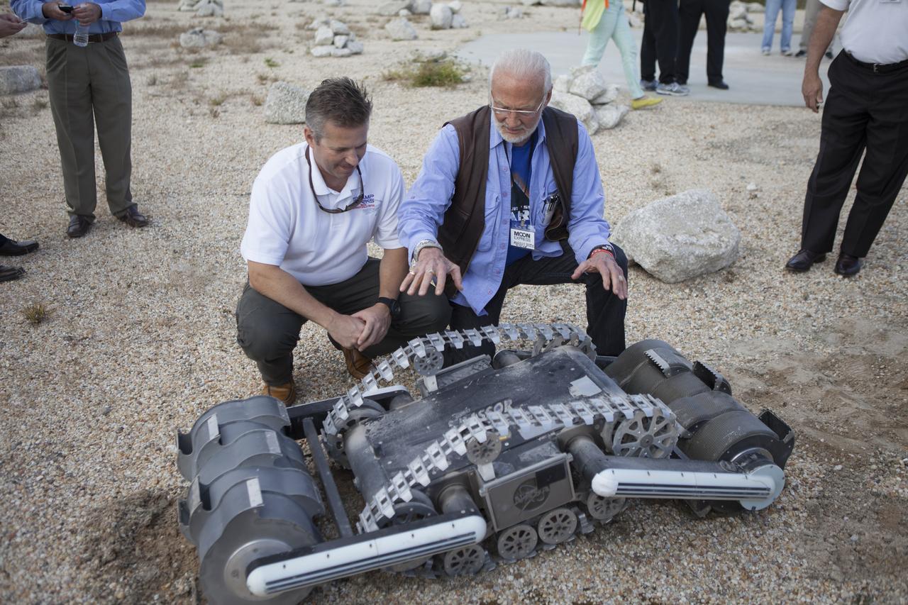 Rob Mueller, left, NASA senior technologist in the Surface Systems Office in Kennedy Space Center's Engineering and Technology Directorate, talks with former NASA Apollo astronaut Buzz Aldrin during a demonstration of the Regolith Advanced Surface Systems Operations Robot, or RASSOR, at the automated landing and hazard avoidance technology, or ALHAT, hazard field at the north end of the Shuttle Landing Facility at NASA's Kennedy Space Center in Florida. The event was held to announce Moon Express Inc., of Moffett Field, California is selected to utilize Kennedy facilities for NASA's Lunar Cargo Transportation and Landing by Soft Touchdown, or Lunar CATALYST, initiative. Moon Express is developing a lander with capabilities that will enable delivery of payloads to the surface of the moon, as well as new science and exploration missions of interest to NASA and scientific and academic communities. Moon Express will base its activities at Kennedy and utilize the Morpheus ALHAT field and a hangar nearby for CATALYST testing. The Advanced Exploration Systems Division of NASA's Human Exploration and Operations Mission Directorate manages Lunar CATALYST.