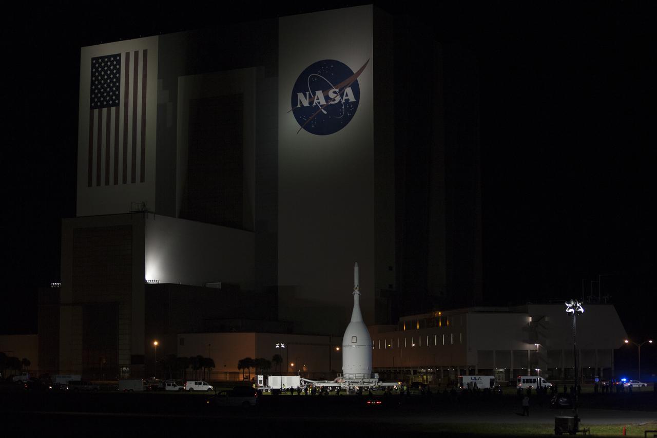 At NASA's Kennedy Space Center in Florida, the agency's Orion spacecraft passes the spaceport's iconic Vehicle Assembly Building as it is transported to Launch Complex 37 at Cape Canaveral Air Force Station. After arrival at the launch pad, United Launch Alliance engineers and technicians will lift Orion and mount it atop its Delta IV Heavy rocket. Orion is the exploration spacecraft designed to carry astronauts to destinations not yet explored by humans, including an asteroid and Mars. It will have emergency abort capability, sustain the crew during space travel and provide safe re-entry from deep space return velocities. The first unpiloted flight test of Orion is scheduled to launch Dec. 4, 2014 atop a United Launch Alliance Delta IV Heavy rocket, and in 2018 on NASA’s Space Launch System rocket.