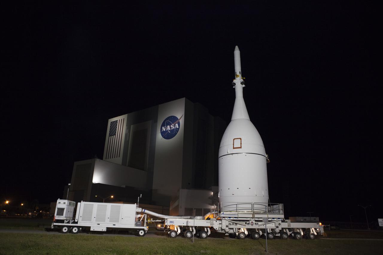 At NASA's Kennedy Space Center in Florida, the agency's Orion spacecraft passes the spaceport's iconic Vehicle Assembly Building as it is transported to Launch Complex 37 at Cape Canaveral Air Force Station. After arrival at the launch pad, United Launch Alliance engineers and technicians will lift Orion and mount it atop its Delta IV Heavy rocket. Orion is the exploration spacecraft designed to carry astronauts to destinations not yet explored by humans, including an asteroid and Mars. It will have emergency abort capability, sustain the crew during space travel and provide safe re-entry from deep space return velocities. The first unpiloted flight test of Orion is scheduled to launch Dec. 4, 2014 atop a United Launch Alliance Delta IV Heavy rocket, and in 2018 on NASA’s Space Launch System rocket.