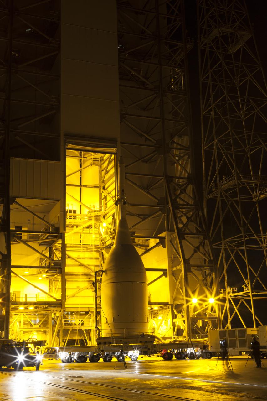The Orion spacecraft and its transporter stand at the base of the service structure at Space Launch Complex 37. A crane inside the structure will lift Orion off its transporter to hoist it into place atop the Delta IV Heavy rocket that is already assembled at the pad. Orion is the exploration spacecraft designed to carry astronauts to destinations not yet explored by humans, including an asteroid and Mars. It will have emergency abort capability, sustain the crew during space travel and provide safe re-entry from deep space return velocities. The first unpiloted flight test of Orion is scheduled to launch Dec. 4, 2014, atop a United Launch Alliance Delta IV Heavy rocket, and in 2018 on NASA’s Space Launch System rocket.
