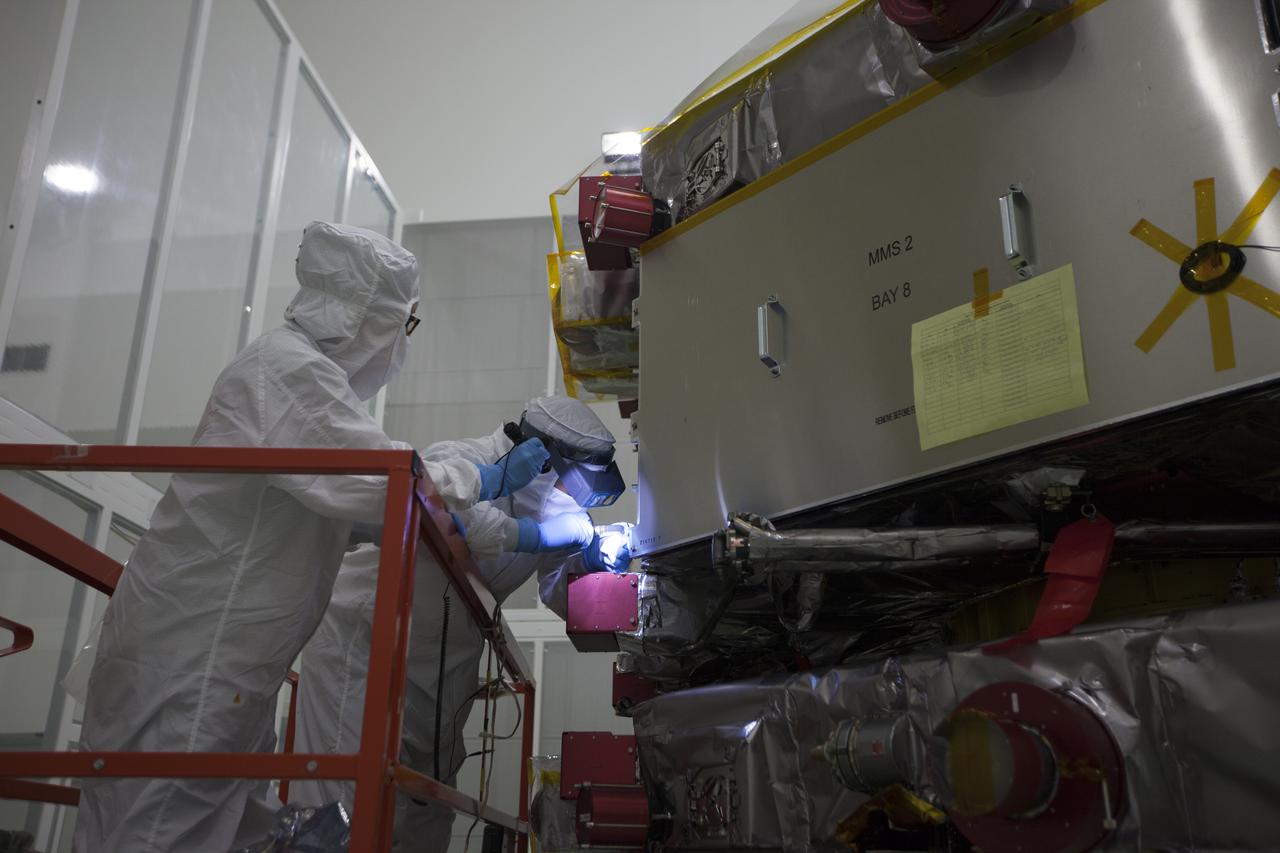 Workers inspect the solar arrays on the Magnetospheric Multiscale, or MMS, observatories in the Building 1 D high bay of the Astrotech payload processing facility in Titusville, Florida, near Kennedy Space Center. The two MMS spacecraft comprising the upper deck arrived Nov. 12; the two comprising the lower stack arrived Oct. 29. MMS, led by a team from NASA's Goddard Space Flight Center, is a Solar Terrestrial Probes mission consisting of four identically instrumented spacecraft that will use Earth’s magnetosphere as a laboratory to study the microphysics of three fundamental plasma processes: magnetic reconnection, energetic particle acceleration and turbulence. Launch aboard a United Launch Alliance Atlas V rocket from Space Launch Complex 41 on Cape Canaveral Air Force Station is targeted for March 12, 2015.