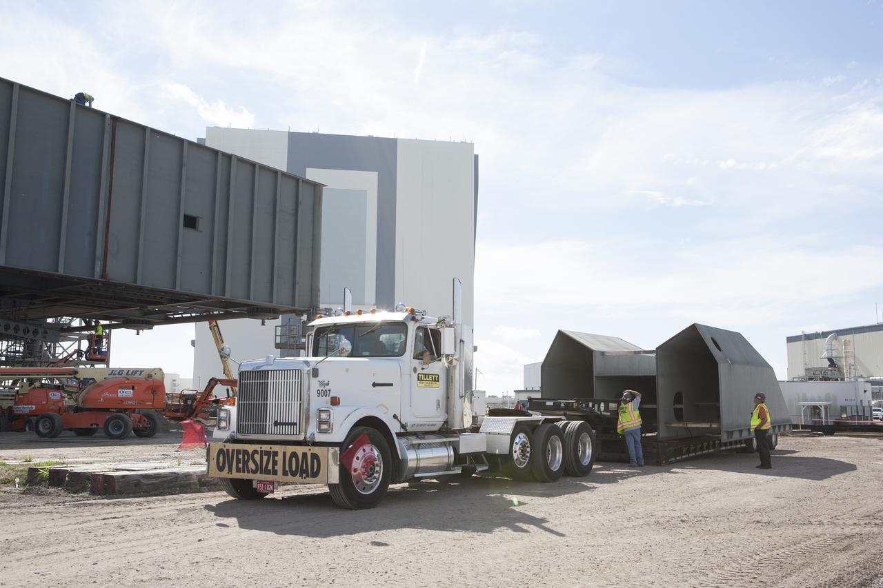 Modifications continue on the Mobile Launcher, or ML, at the Mobile Launcher Park Site at NASA’s Kennedy Space Center in Florida. The haunch, a structure that will support the launch vehicle on the ML, arrives by flatbed truck at the park site. The ML is being modified and strengthened to accommodate the weight, size and thrust at launch of NASA's Space Launch System, or SLS, and Orion spacecraft. In 2013, the agency awarded a contract to J.P. Donovan Construction Inc. of Rockledge, Fla., to modify the ML, which is one of the key elements of ground support equipment that is being upgraded by the Ground Systems Development and Operations Program at Kennedy. The existing 24-foot exhaust hole is being enlarged and strengthened for the larger, heavier SLS rocket. The ML will carry the SLS rocket and Orion spacecraft to Launch Pad 39B for its first uncrewed mission, Exploration Mission-1, in 2018.