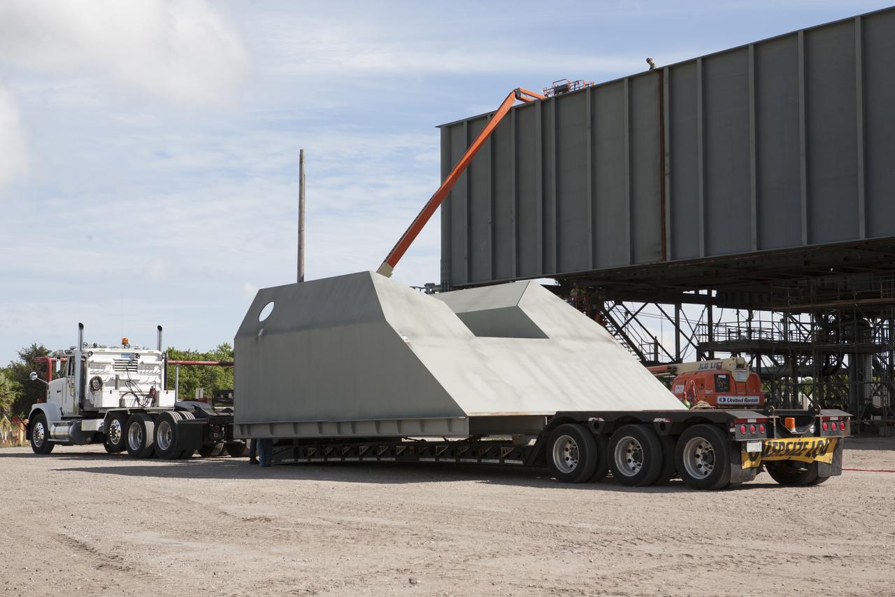 Modifications continue on the Mobile Launcher, or ML, at the Mobile Launcher Park Site at NASA’s Kennedy Space Center in Florida. The haunch, a structure that will support the launch vehicle on the ML, arrives by flatbed truck at the park site. The ML is being modified and strengthened to accommodate the weight, size and thrust at launch of NASA's Space Launch System, or SLS, and Orion spacecraft. In 2013, the agency awarded a contract to J.P. Donovan Construction Inc. of Rockledge, Fla., to modify the ML, which is one of the key elements of ground support equipment that is being upgraded by the Ground Systems Development and Operations Program at Kennedy. The existing 24-foot exhaust hole is being enlarged and strengthened for the larger, heavier SLS rocket. The ML will carry the SLS rocket and Orion spacecraft to Launch Pad 39B for its first uncrewed mission, Exploration Mission-1, in 2018. 