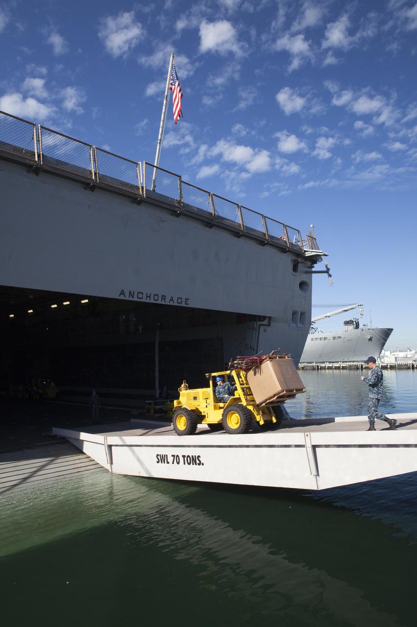 A forklift is used to carry ground support equipment into the well deck of the USS Anchorage at Naval Base San Diego in California. The equipment will be used during recovery of the Orion crew module after its first flight test. Before launch of Orion on a Delta IV Heavy rocket from Cape Canaveral Air Force Station in Florida, NASA, Lockheed Martin and U.S. Navy personnel will head out to sea in the USS Anchorage and the USNS Salvor, a salvage ship, and wait for splashdown of the Orion crew module in the Pacific Ocean. The Ground Systems Development and Operations Program will lead the recovery efforts. Orion is the exploration spacecraft designed to carry astronauts to destinations not yet explored by humans, including an asteroid and Mars. It will have emergency abort capability, sustain the crew during space travel and provide safe re-entry from deep space return velocities. The first unpiloted flight test of Orion is scheduled to launch in December atop a United Launch Alliance Delta IV Heavy rocket and in 2018 on NASA’s Space Launch System rocket. 