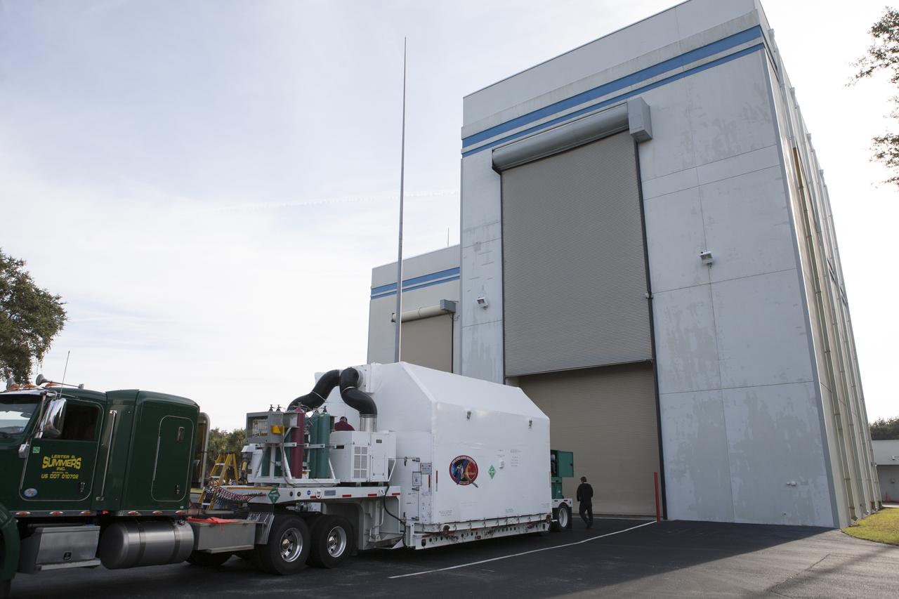 The truck delivering NOAA’s Deep Space Climate Observatory spacecraft, or DSCOVR, enclosed in a protective shipping container, backs up to the door of the airlock of Building 2 at the Astrotech payload processing facility in Titusville, Florida, near Kennedy Space Center. DSCOVR is a partnership between NOAA, NASA and the U.S. Air Force. DSCOVR will maintain the nation's real-time solar wind monitoring capabilities which are critical to the accuracy and lead time of NOAA's space weather alerts and forecasts. Launch is currently scheduled for January 2015 aboard a SpaceX Falcon 9 v 1.1 launch vehicle from Cape Canaveral Air Force Station, Florida.