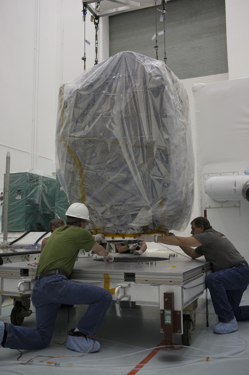 Workers align NOAA’s Deep Space Climate Observatory spacecraft, or DSCOVR, wrapped in plastic, onto a portable work stand at the Astrotech payload processing facility in Titusville, Florida, near Kennedy Space Center. DSCOVR is a partnership between NOAA, NASA and the U.S. Air Force. DSCOVR will maintain the nation's real-time solar wind monitoring capabilities which are critical to the accuracy and lead time of NOAA's space weather alerts and forecasts. Launch is currently scheduled for January 2015 aboard a SpaceX Falcon 9 v 1.1 launch vehicle from Cape Canaveral Air Force Station, Florida. 
