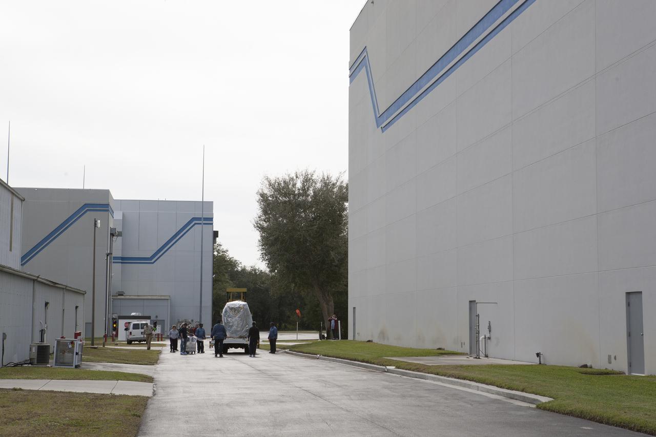 Workers monitor NOAA’s Deep Space Climate Observatory spacecraft, or DSCOVR, wrapped in plastic and secured onto a portable work stand, as it travels between the airlock of Building 2 to the high bay of Building 1 at the Astrotech payload processing facility in Titusville, Florida, near Kennedy Space Center. DSCOVR is a partnership between NOAA, NASA and the U.S. Air Force. DSCOVR will maintain the nation's real-time solar wind monitoring capabilities which are critical to the accuracy and lead time of NOAA's space weather alerts and forecasts. Launch is currently scheduled for January 2015 aboard a SpaceX Falcon 9 v 1.1 launch vehicle from Cape Canaveral Air Force Station, Florida.