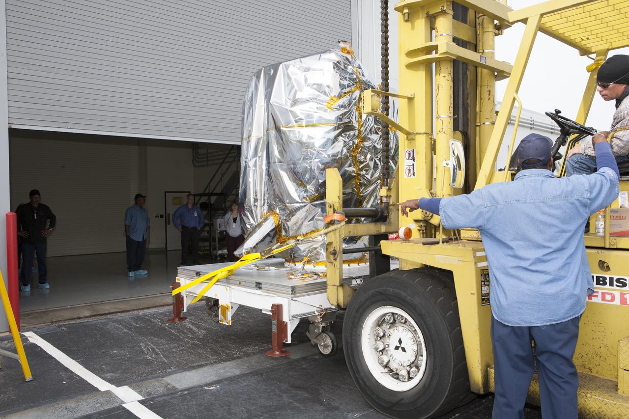NOAA’s newly arrived Deep Space Climate Observatory spacecraft, or DSCOVR, wrapped in plastic and secured onto a portable work stand, is delivered to the high bay of Building 1 at the Astrotech payload processing facility in Titusville, Florida, near Kennedy Space Center. DSCOVR is a partnership between NOAA, NASA and the U.S. Air Force. DSCOVR will maintain the nation's real-time solar wind monitoring capabilities which are critical to the accuracy and lead time of NOAA's space weather alerts and forecasts. Launch is currently scheduled for January 2015 aboard a SpaceX Falcon 9 v 1.1 launch vehicle from Cape Canaveral Air Force Station, Florida. 