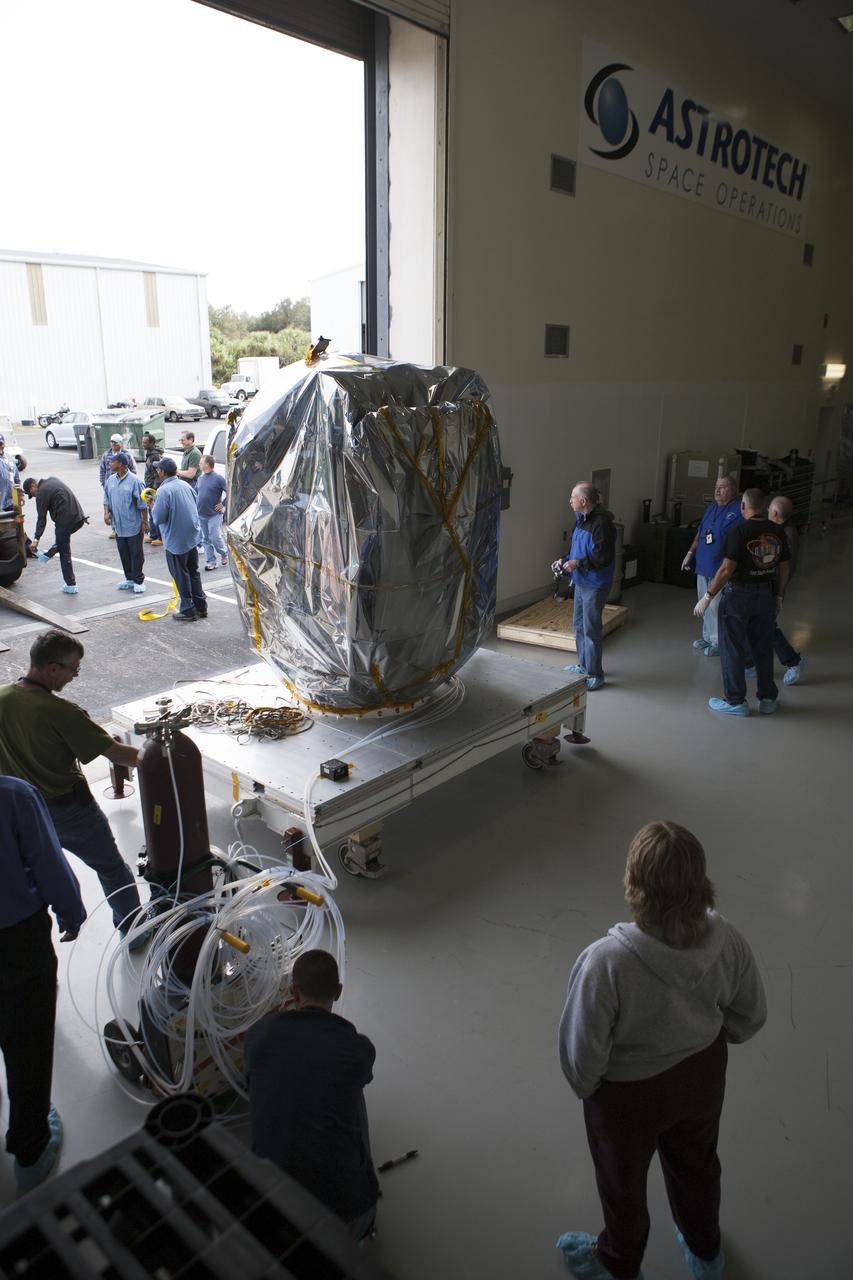 Workers are on hand to receive NOAA’s Deep Space Climate Observatory spacecraft, or DSCOVR, wrapped in plastic and secured onto a portable work stand, into the high bay of Building 1 at the Astrotech payload processing facility in Titusville, Florida, near Kennedy Space Center. DSCOVR is a partnership between NOAA, NASA and the U.S. Air Force. DSCOVR will maintain the nation's real-time solar wind monitoring capabilities which are critical to the accuracy and lead time of NOAA's space weather alerts and forecasts. Launch is currently scheduled for January 2015 aboard a SpaceX Falcon 9 v 1.1 launch vehicle from Cape Canaveral Air Force Station, Florida.
