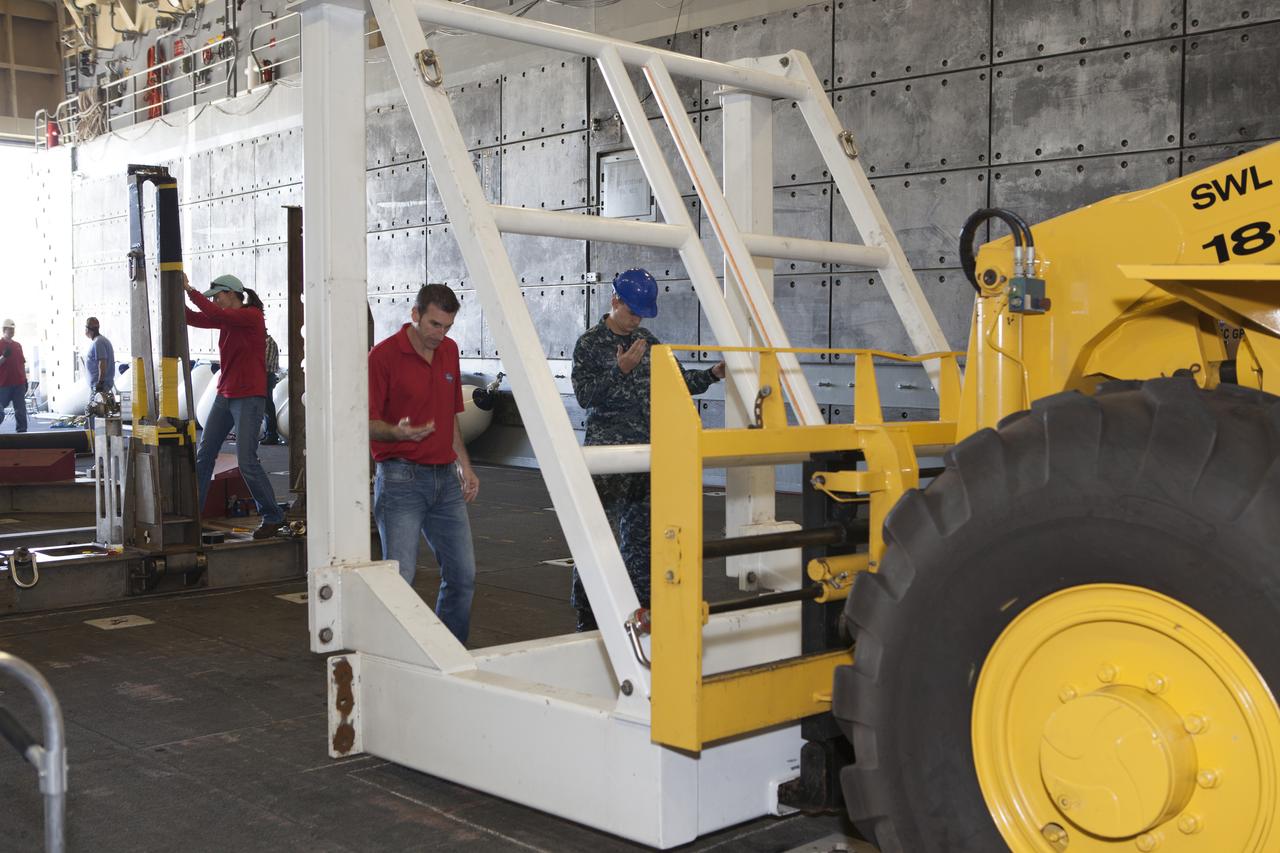 A forklift is used to set the Orion handling fixture down in the well deck of the USS Anchorage at Naval Base San Diego in California. The fixture and other ground support equipment will be used during recovery of the Orion crew module after its first flight test. Before launch of Orion on a Delta IV Heavy rocket from Cape Canaveral Air Force Station in Florida, NASA, Lockheed Martin and U.S. Navy personnel will head out to sea in the USS Anchorage and the USNS Salvor, a salvage ship, and wait for splashdown of the Orion crew module in the Pacific Ocean. The Ground Systems Development and Operations Program will lead the recovery efforts. Orion is the exploration spacecraft designed to carry astronauts to destinations not yet explored by humans, including an asteroid and Mars. It will have emergency abort capability, sustain the crew during space travel and provide safe re-entry from deep space return velocities. The first unpiloted flight test of Orion is scheduled to launch in December atop a United Launch Alliance Delta IV Heavy rocket and in 2018 on NASA’s Space Launch System rocket.
