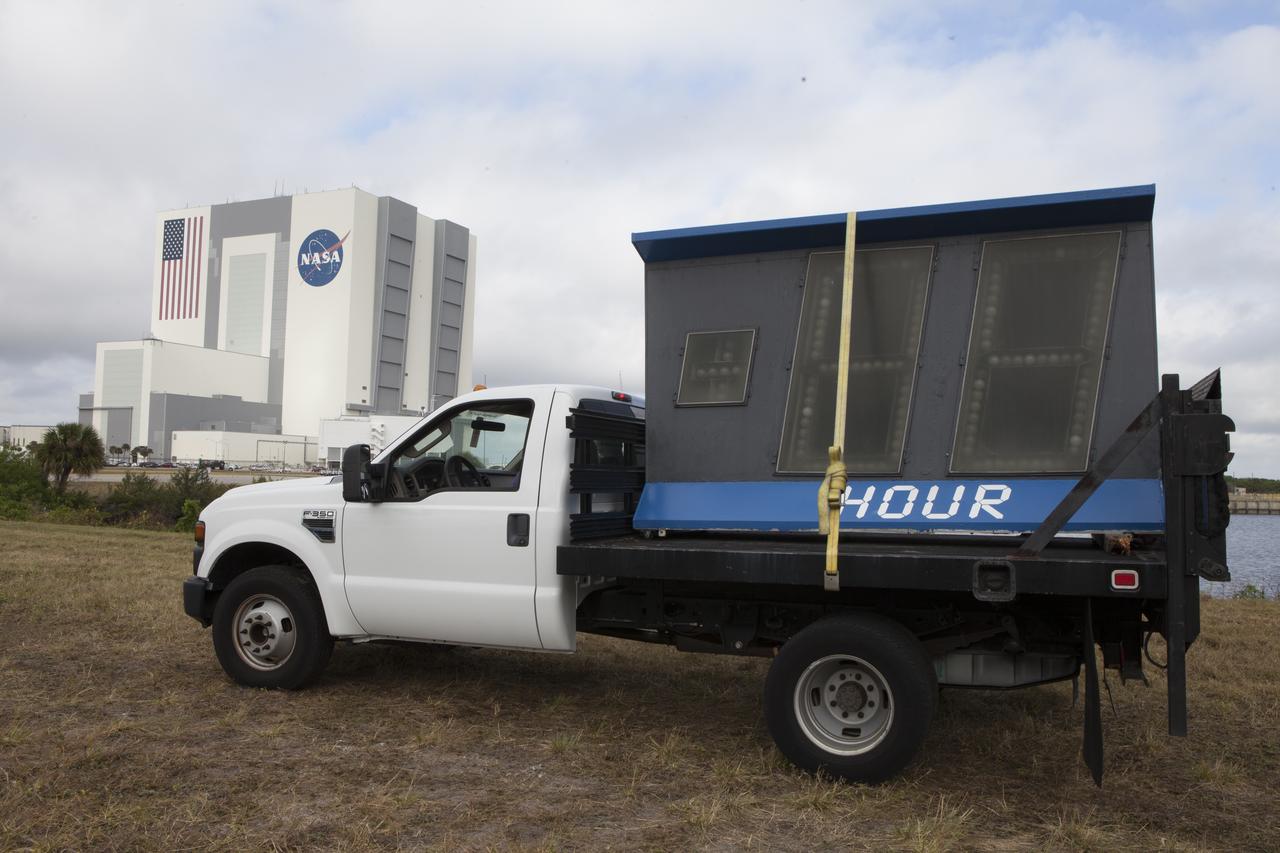 At NASA's Kennedy Space Center in Florida, the historic countdown clock at the spaceport's Press Site is disassembled for removal. Kennedy has requested to acquire the countdown clock from the agency’s Artifact Working Group at NASA Headquarters for likely display at the Kennedy Space Center Visitor Complex. A new modern multimedia display soon will be installed, similar to the screens seen at sporting venues, is in the works. The new screen will be nearly 26 feet wide by 7 feet high. The old timepiece was designed by Kennedy engineers and built by Kennedy technicians in 1969. Not including the triangular concrete and aluminum base, the famous landmark is nearly six feet high, 26 feet wide and 3 feet deep. The new display will be similar in size, with the screen being nearly 26 feet wide by seven feet high.