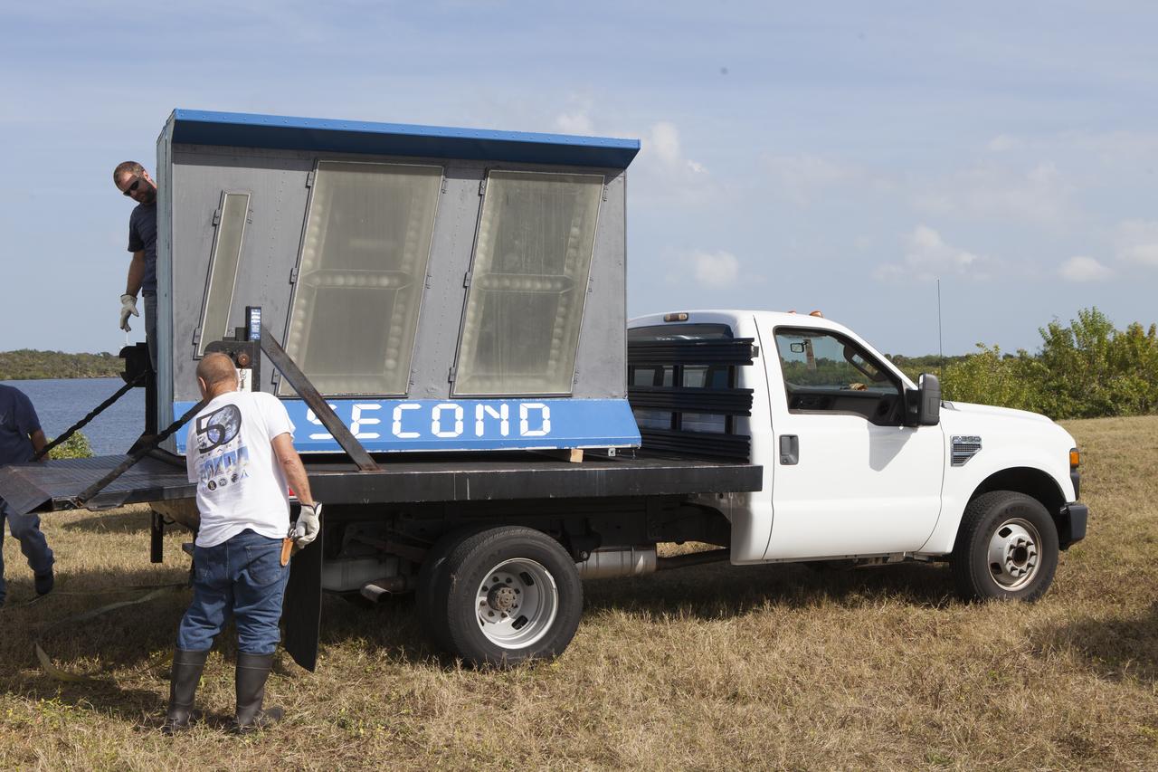 At NASA's Kennedy Space Center in Florida, the historic countdown clock at the spaceport's Press Site is disassembled for removal. Kennedy has requested to acquire the countdown clock from the agency’s Artifact Working Group at NASA Headquarters for likely display at the Kennedy Space Center Visitor Complex. A new modern multimedia display soon will be installed, similar to the screens seen at sporting venues, is in the works. The new screen will be nearly 26 feet wide by 7 feet high. The old timepiece was designed by Kennedy engineers and built by Kennedy technicians in 1969. Not including the triangular concrete and aluminum base, the famous landmark is nearly six feet high, 26 feet wide and 3 feet deep. The new display will be similar in size, with the screen being nearly 26 feet wide by seven feet high.