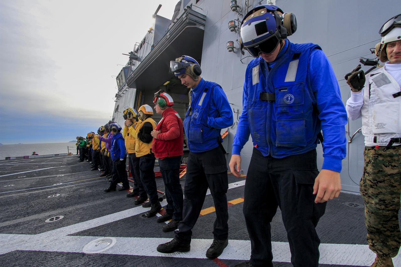 Helicopter Sea Combat Squadron 8 personnel review procedures on the deck of the USS Anchorage as the ship departs Naval Base San Diego in California for the open waters of the Pacific Ocean. NASA and the U.S. Navy are making preparations ahead of Orion's flight test for recovery of the crew module, forward bay cover and parachutes on its return from space and splashdown in the Pacific Ocean. The Ground Systems Development and Operations Program is leading the recovery efforts.