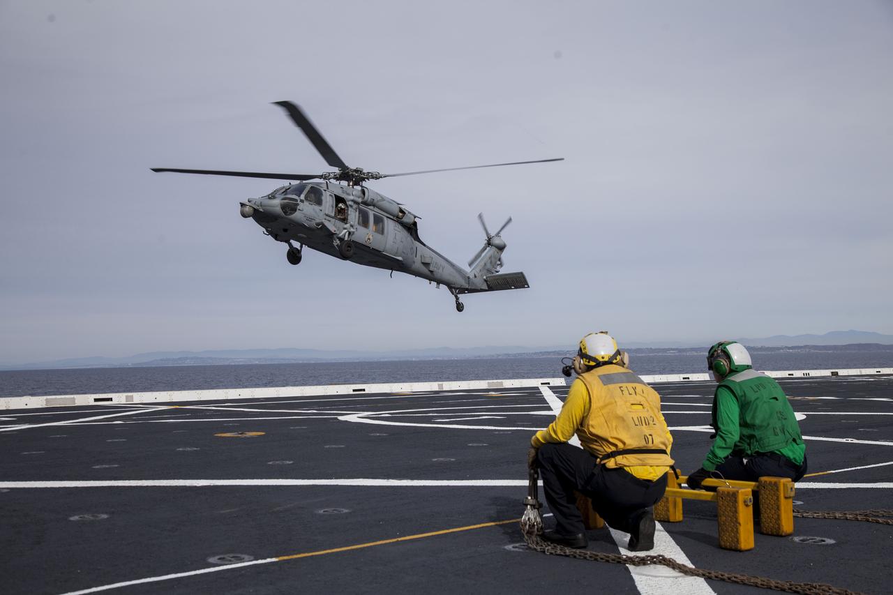An H60-S Seahawk helicopter lands on the deck of the USS Anchorage in the Pacific Ocean off the coast of California. NASA and the U.S. Navy are heading out to sea ahead of Orion's flight test to prepare for recovery of the crew module, forward bay cover and parachutes on its return from space and splashdown in the Pacific Ocean. The Ground Systems Development and Operations Program is leading the recovery efforts.