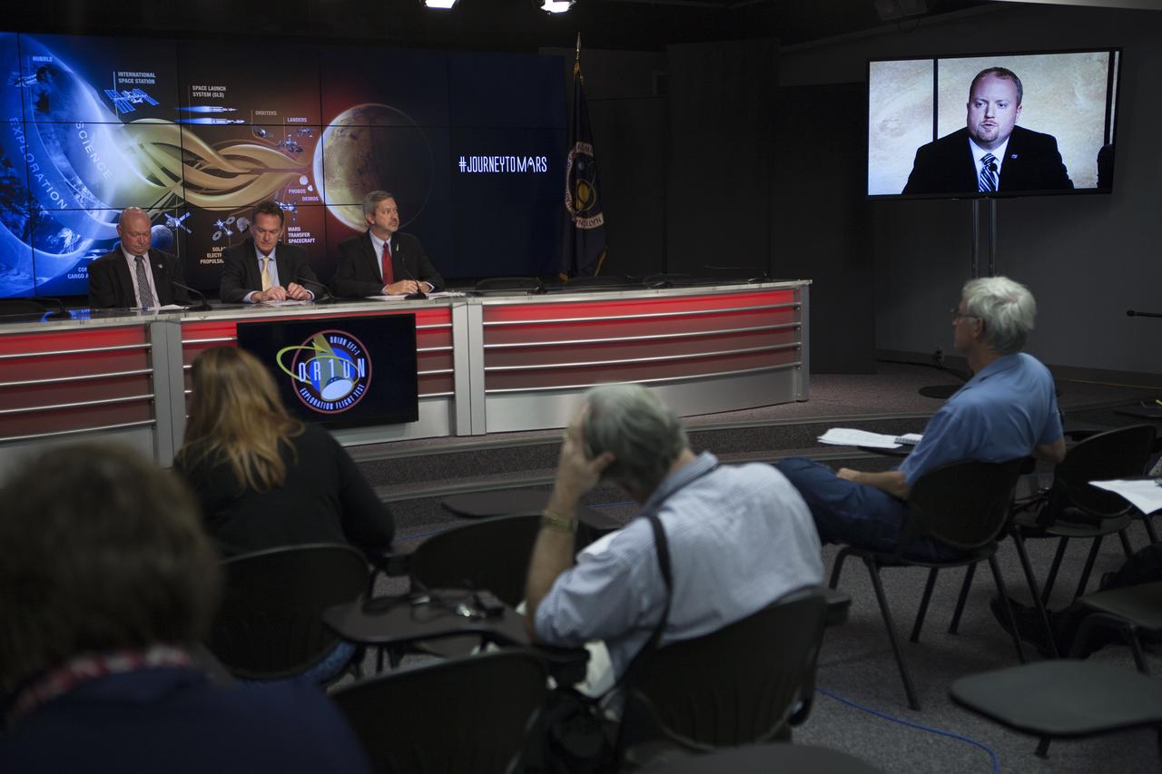 At NASA's Kennedy Space Center in Florida, NASA leaders spoke to members of the news media about how the first flight of the new Orion spacecraft is a first step in the agency's plans to send humans to Mars. At Kennedy's News Center auditorium from the left are: Mike Curie of NASA Public Affairs, Mike Bolger, program manager of Ground Systems Development and Operations Program, and Chris Crumbly, manager of Space Launch System Spacecraft/Payload Integration and Evolution. Participating via video from the agency's headquarters in Washington included Jason Crusan, director of Advanced Exploration Systems Division of Human Exploration and Operations Mission Directorate, seen on the monitor on the right. Orion is the exploration spacecraft designed to carry astronauts to destinations not yet explored by humans, including an asteroid and Mars. It will have emergency abort capability, sustain the crew during space travel and provide safe re-entry from deep space return velocities. The first unpiloted flight test of Orion is scheduled to launch Dec. 4, 2014 atop a United Launch Alliance Delta IV Heavy rocket, and in 2018 on NASA’s Space Launch System rocket.