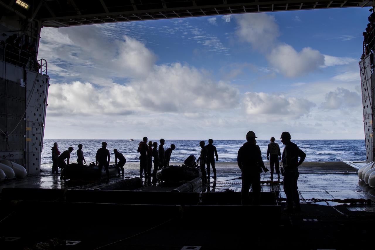 On the third day of preparations for recovery of Orion after its splashdown in the Pacific Ocean, U.S. Navy Divers prepare to embark from the well deck of the USS Anchorage in two rigid hull Zodiac boats about 600 miles off the coast of Baja, California. NASA, Lockheed Martin and U.S. Navy personnel are preparing for recovery of the crew module, forward bay cover and parachutes on its return from space and splashdown in the Pacific Ocean. The Ground Systems Development and Operations Program is leading the recovery efforts. 