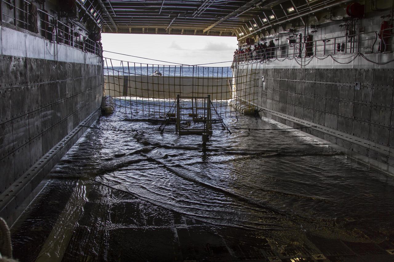 On the third day of preparations for recovery of Orion after its splashdown in the Pacific Ocean, the well deck of the USS Anchorage has been filled with water and recovery hardware is in place. The ship is about 600 miles off the coast of Baja, California. NASA, Lockheed Martin and U.S. Navy personnel are preparing for recovery of the crew module, forward bay cover and parachutes on its return from space and splashdown in the Pacific Ocean. The Ground Systems Development and Operations Program is leading the recovery efforts.