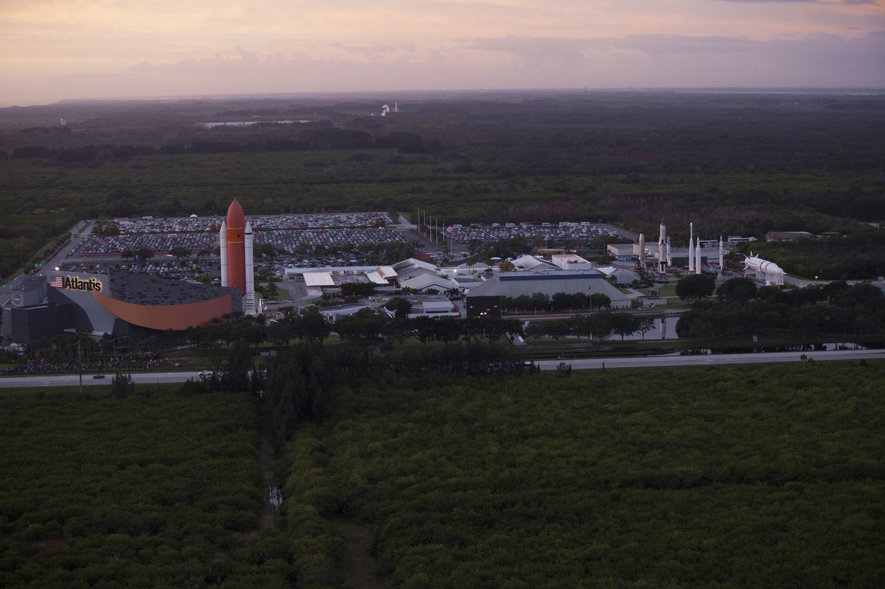 This helicopter view of the Kennedy Space Center Visitor Complex shows the thousands of vehicles parked where guests gather to see the launch of the Orion Flight Test. The liftoff was postponed because of an issue related to fill and drain valves on the Delta IV Heavy rocket that teams could not troubleshoot by the time the launch window expired.