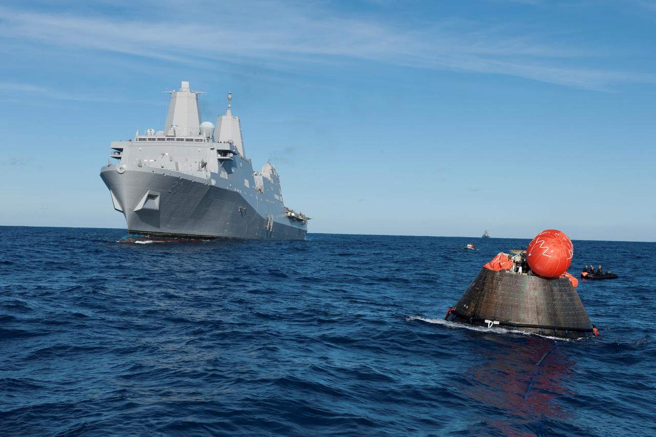 NASA's Orion spacecraft floats in the Pacific Ocean after splashdown from its first flight test in Earth orbit. The USS Anchorage is nearby. NASA, the U.S. Navy and Lockheed Martin are coordinating efforts to recover Orion and secure the spacecraft in the well deck of the USS Anchorage. Orion completed a two-orbit, four-and-a-half hour mission, to test systems critical to crew safety, including the launch abort system, the heat shield and the parachute system. The Ground Systems Development and Operations Program is leading the recovery efforts.