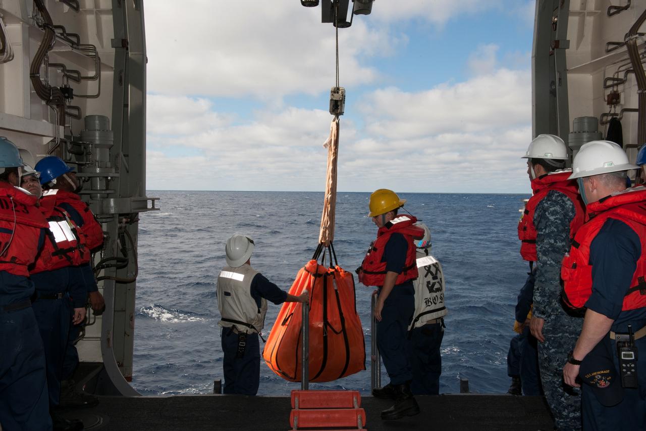 U.S. Navy personnel aboard the USS Anchorage prepare for recovery of NASA's Orion spacecraft from the Pacific Ocean about 600 miles off the coast of San Diego, California. Orion splashed down after its first flight test in Earth orbit. NASA, the U.S. Navy and Lockheed Martin are coordinating efforts to recover Orion and secure the spacecraft in the well deck of the USS Anchorage. Orion completed a two-orbit, four-and-a-half hour mission, to test systems critical to crew safety, including the launch abort system, the heat shield and the parachute system. The Ground Systems Development and Operations Program is leading the recovery efforts.