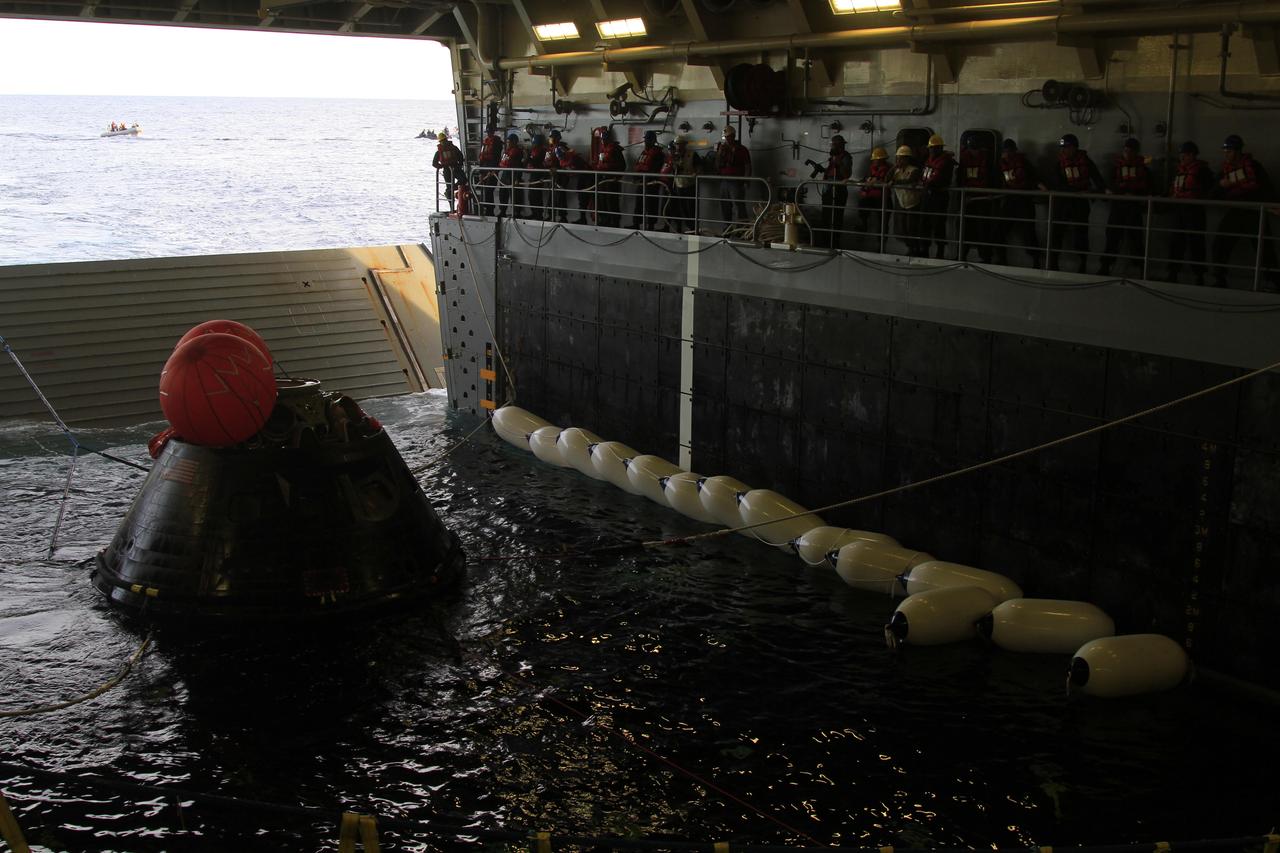 NASA's Orion spacecraft is secured with tether lines inside the flooded well deck of the USS Anchorage in the Pacific Ocean about 600 miles off the coast of San Diego, California. After lifting off at 7:05 a.m. EST atop a Delta IV Heavy rocket from Space Launch Complex 37 at Cape Canaveral Air Force Station in Florida, Orion completed a two-orbit, four-and-a-half hour mission to test systems critical to crew safety, including the launch abort system, the heat shield and the parachute system. NASA, the U.S. Navy and Lockheed Martin coordinated efforts to recover Orion after splashdown. The Ground Systems Development and Operations Program is leading the recovery efforts.
