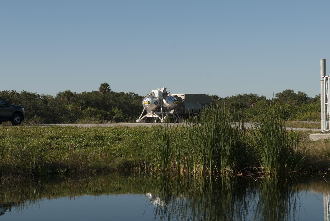 NASA's Project Morpheus prototype lander is being transported to the north end of the Shuttle Landing Facility for free flight test number 15 at NASA’s Kennedy Space Center in Florida. The lander will take off from the ground over a flame trench and use its autonomous landing and hazard avoidance technology, or ALHAT sensors, to survey the hazard field to determine safe landing sites. Project Morpheus tests NASA’s ALHAT and an engine that runs on liquid oxygen and methane, which are green propellants. These new capabilities could be used in future efforts to deliver cargo to planetary surfaces. Project Morpheus is being managed under the Advanced Exploration Systems, or AES, Division in NASA’s Human Exploration and Operations Mission Directorate.