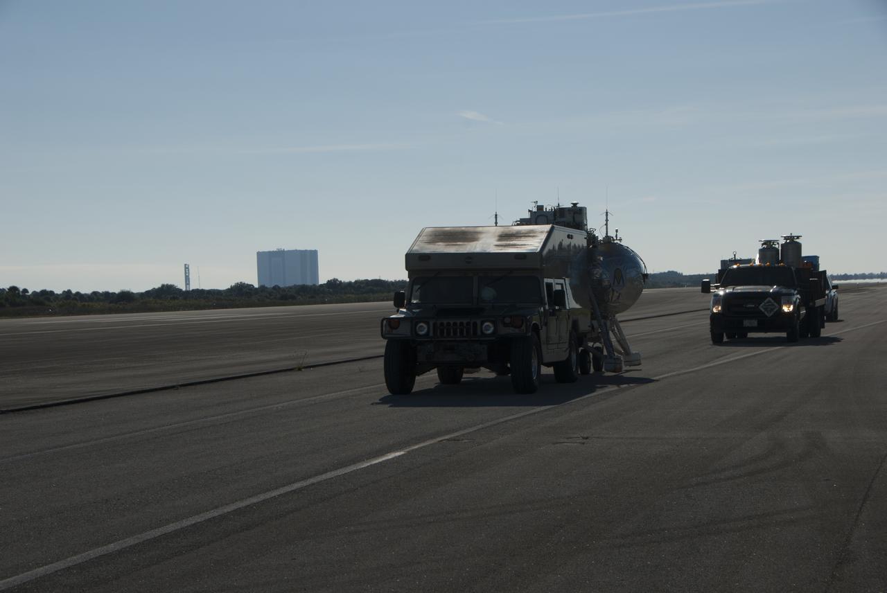 NASA Project Morpheus prototype lander and support equipment are being transported to the north end of the Shuttle Landing Facility for free flight test number 15 at NASA’s Kennedy Space Center in Florida. The lander will take off from the ground over a flame trench and use its autonomous landing and hazard avoidance technology, or ALHAT sensors, to survey the hazard field to determine safe landing sites. Project Morpheus tests NASA’s ALHAT and an engine that runs on liquid oxygen and methane, which are green propellants. These new capabilities could be used in future efforts to deliver cargo to planetary surfaces. Project Morpheus is being managed under the Advanced Exploration Systems, or AES, Division in NASA’s Human Exploration and Operations Mission Directorate. 